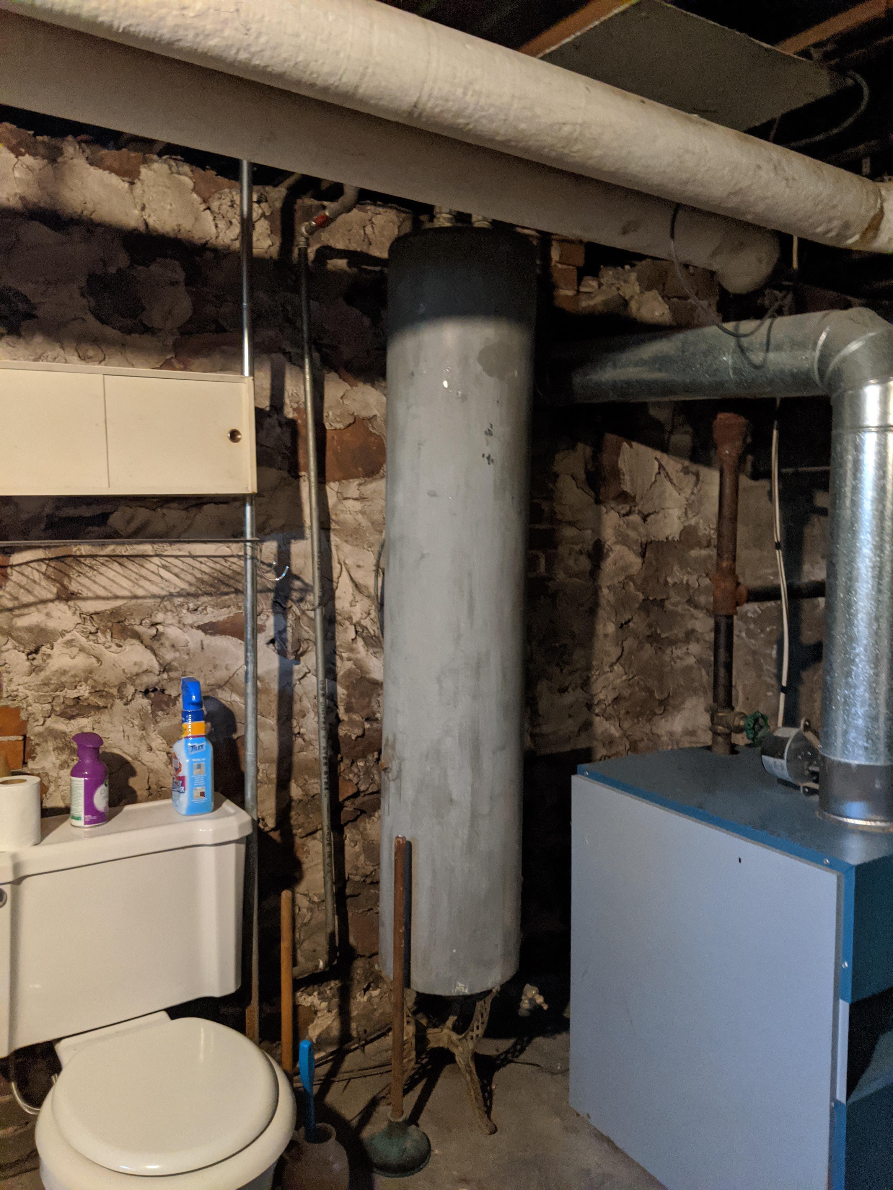 Thin cylinder water tank in basement of house built in 1910. Still hooked up and full of water