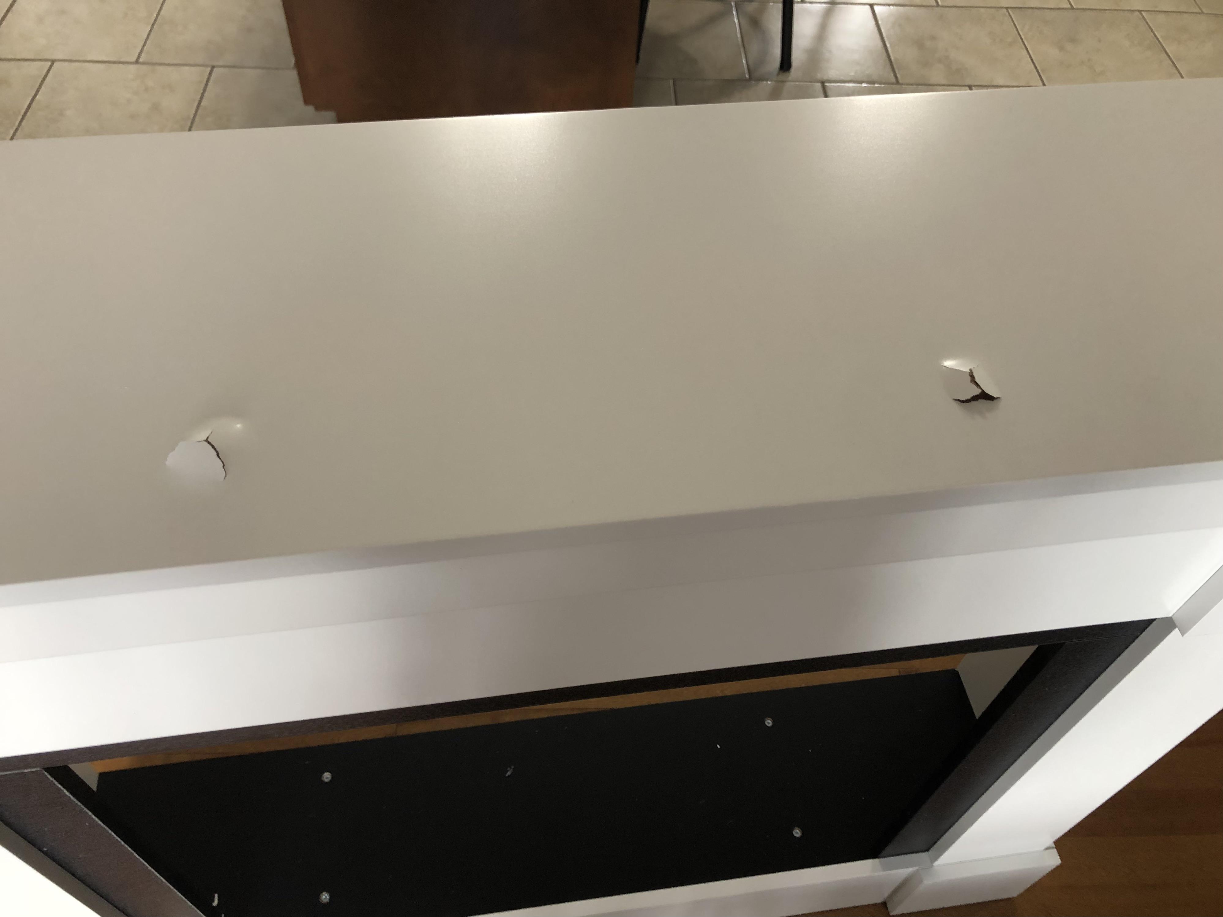 Damage occurred during assembly of this cheap pressboard fireplace