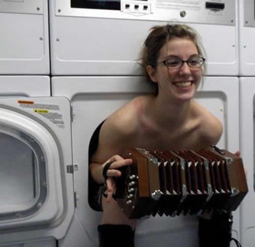 A naked girl in a washing machine holding an accordion : oddlyspecific