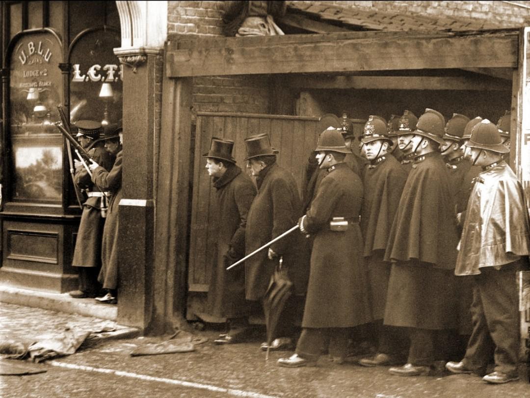 Winston Churchill and several police officers observing the siege of