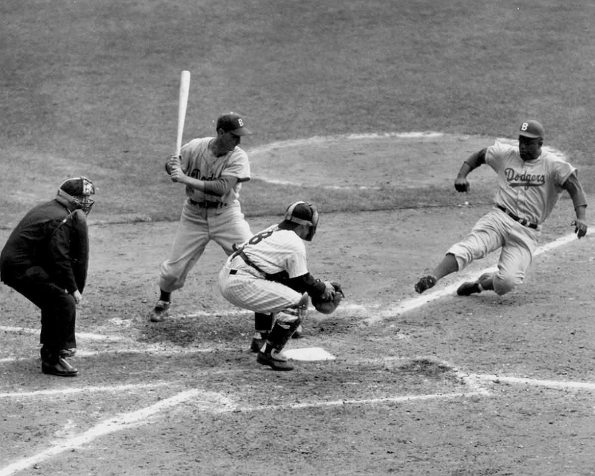 Jackie Robinson with a huge, leaping slide as he attempts to steal home