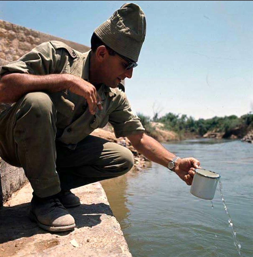 An Israeli soldier drinking water from the Jordan River shortly after