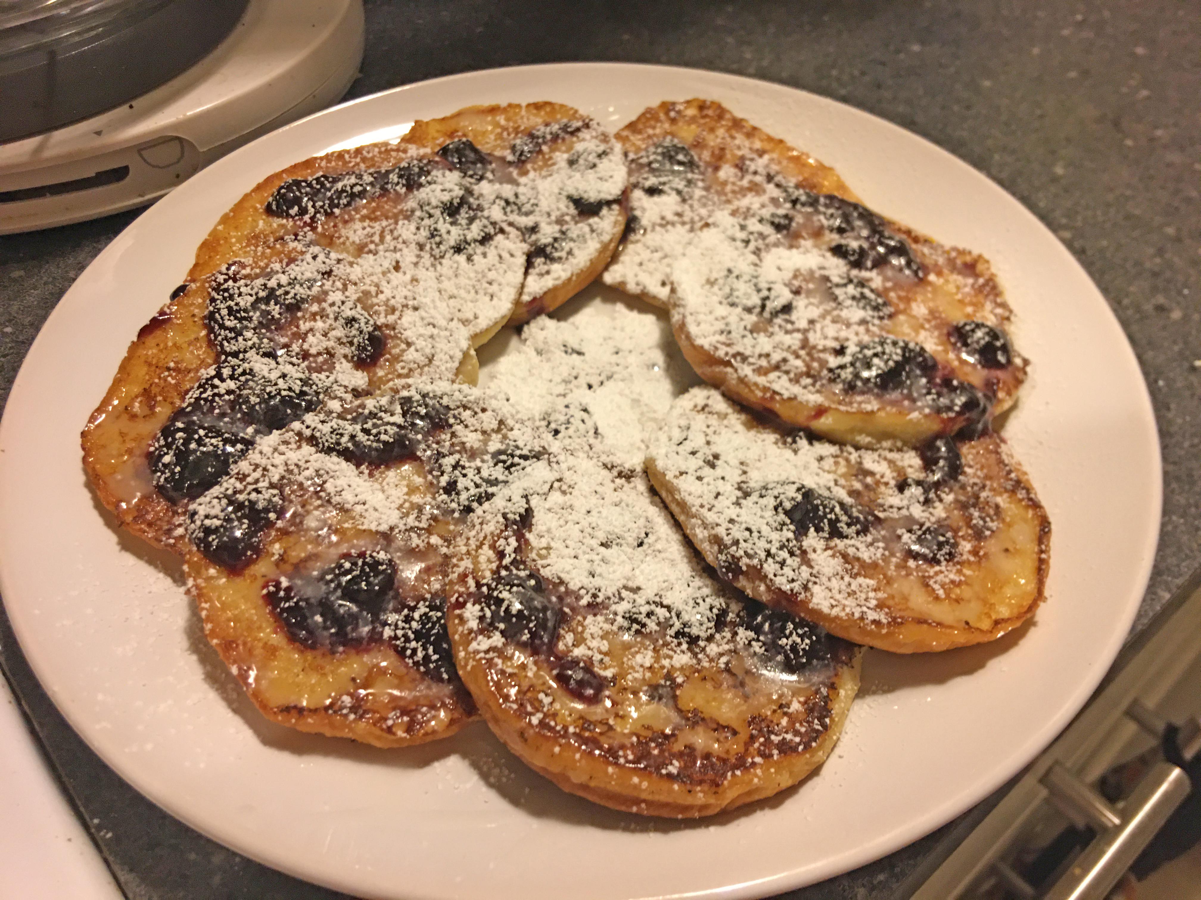 Hamburger bun French toast with blackberry preserves and powdered sugar