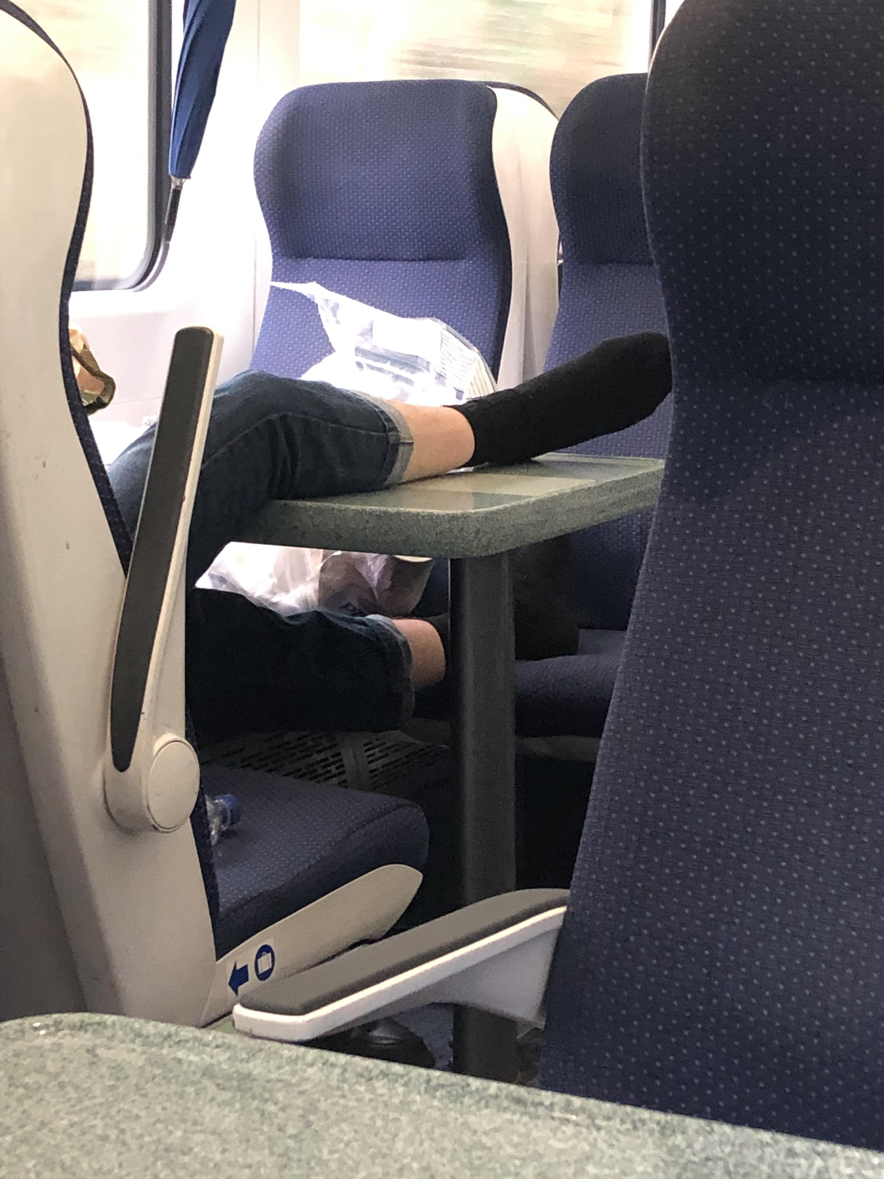 Putting your feet on the table and the chair after taking up a whole