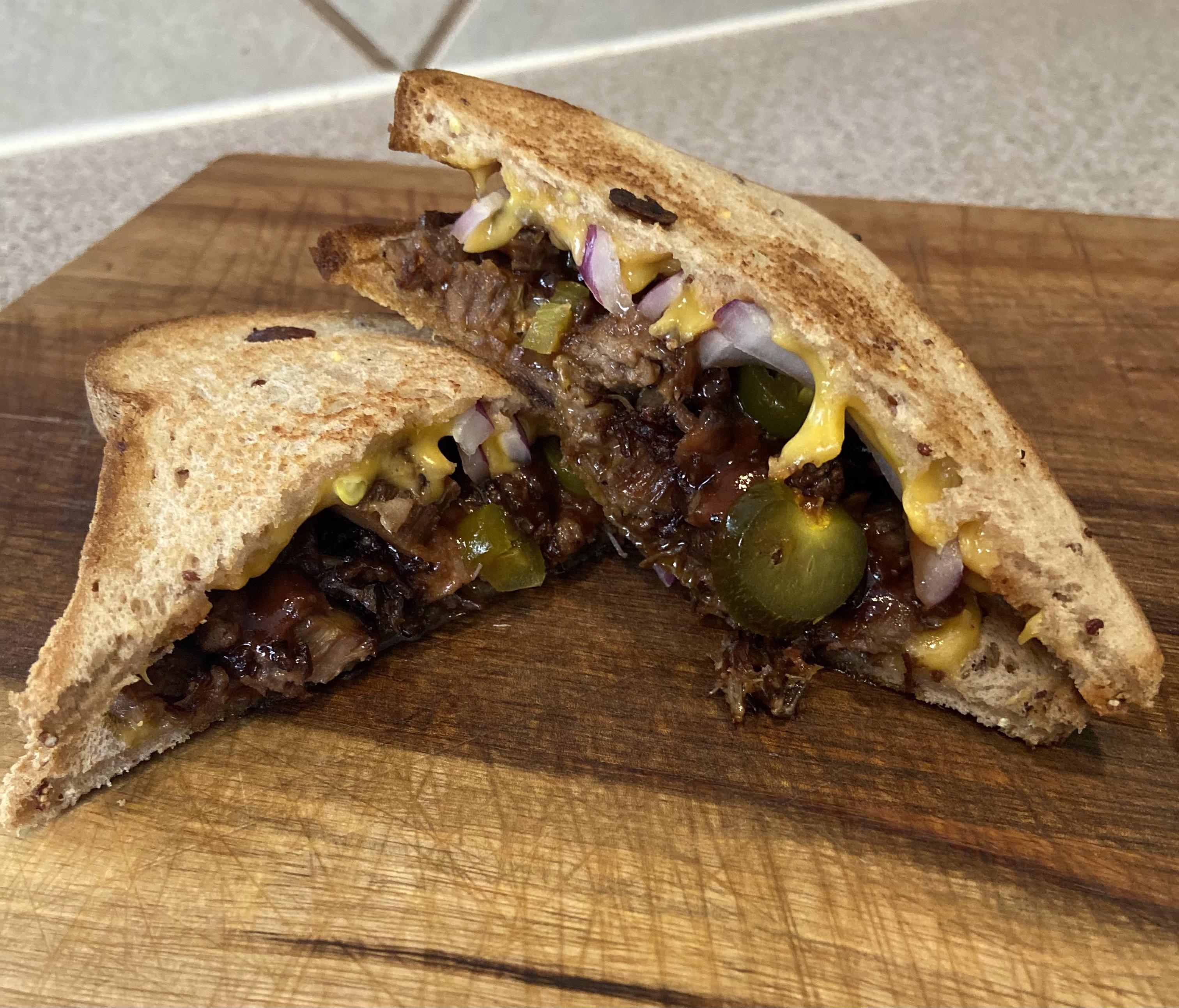 Chopped brisket sandwich with pickled jalapeños, red onion, cheese, and bbq sauce r/glutenfree