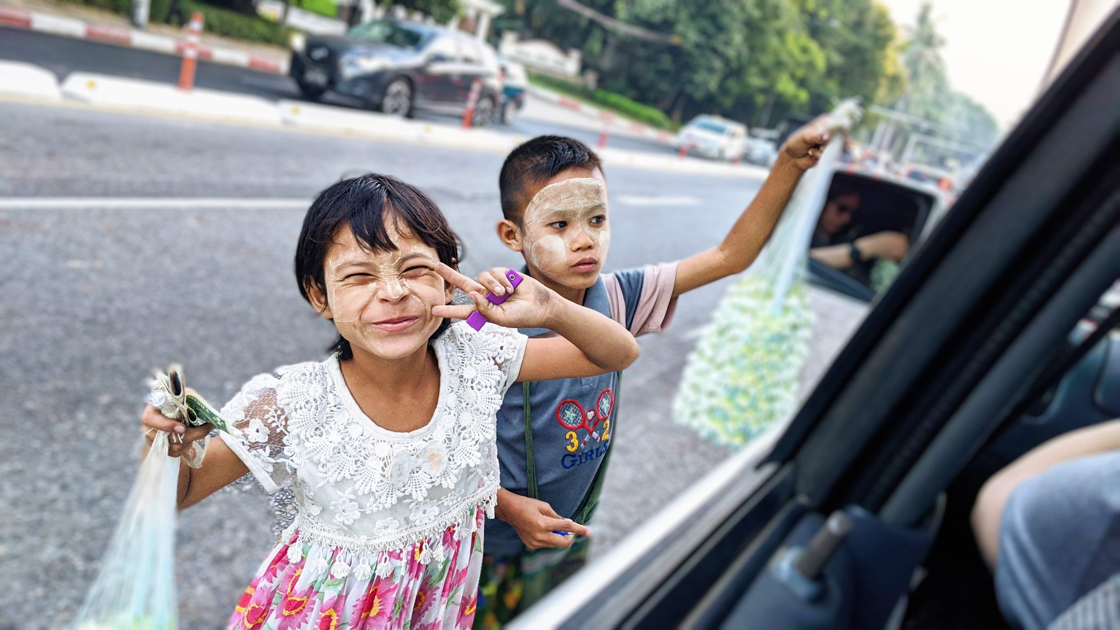 Kids selling flowers on the busy street in Yangon, Myanmar r/pics