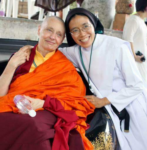 Buddhist nun and Catholic nun pose for a photo. Same mountain different