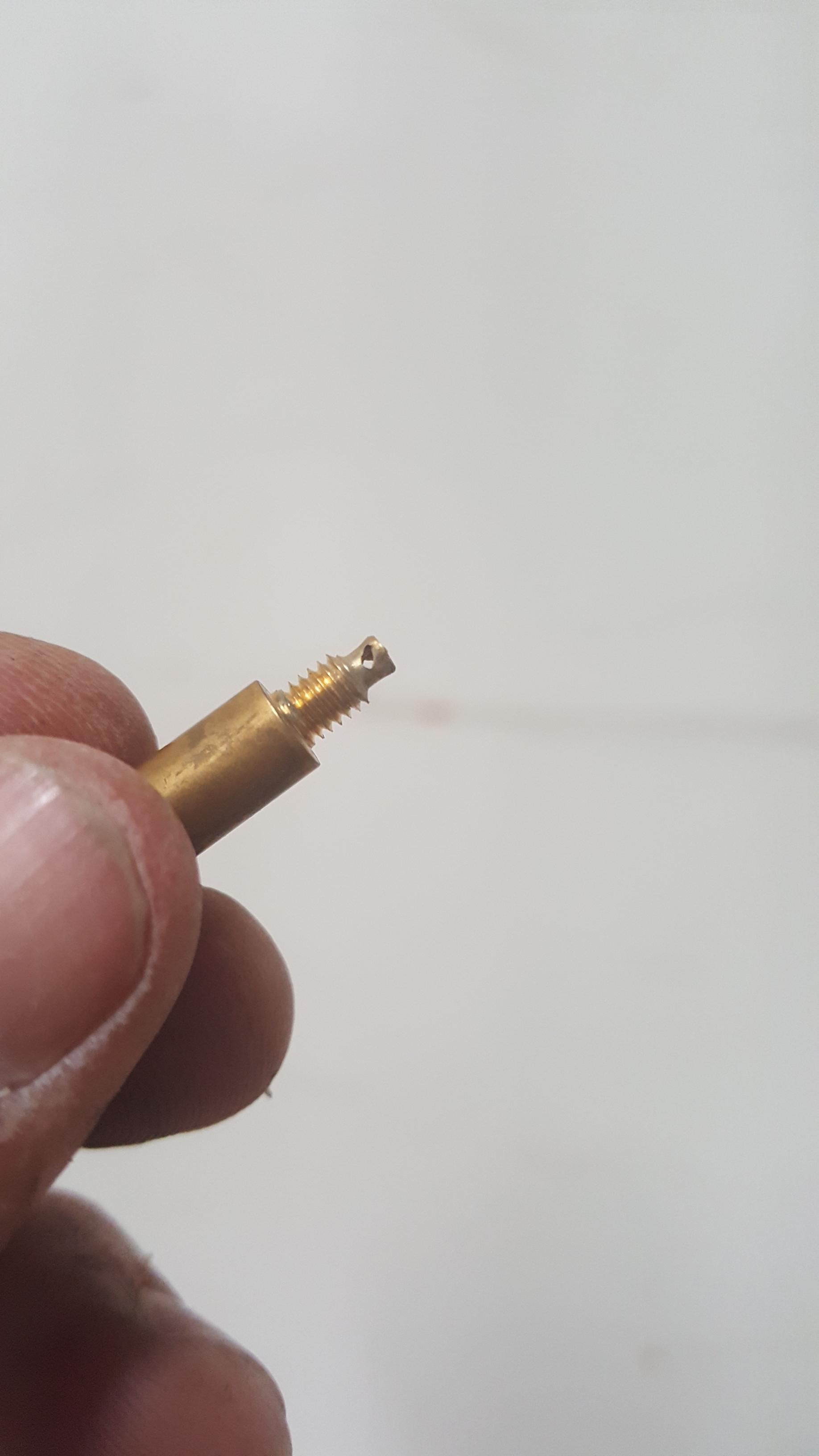 The bottom of this pilot jet is broken off inside its hole. How do I