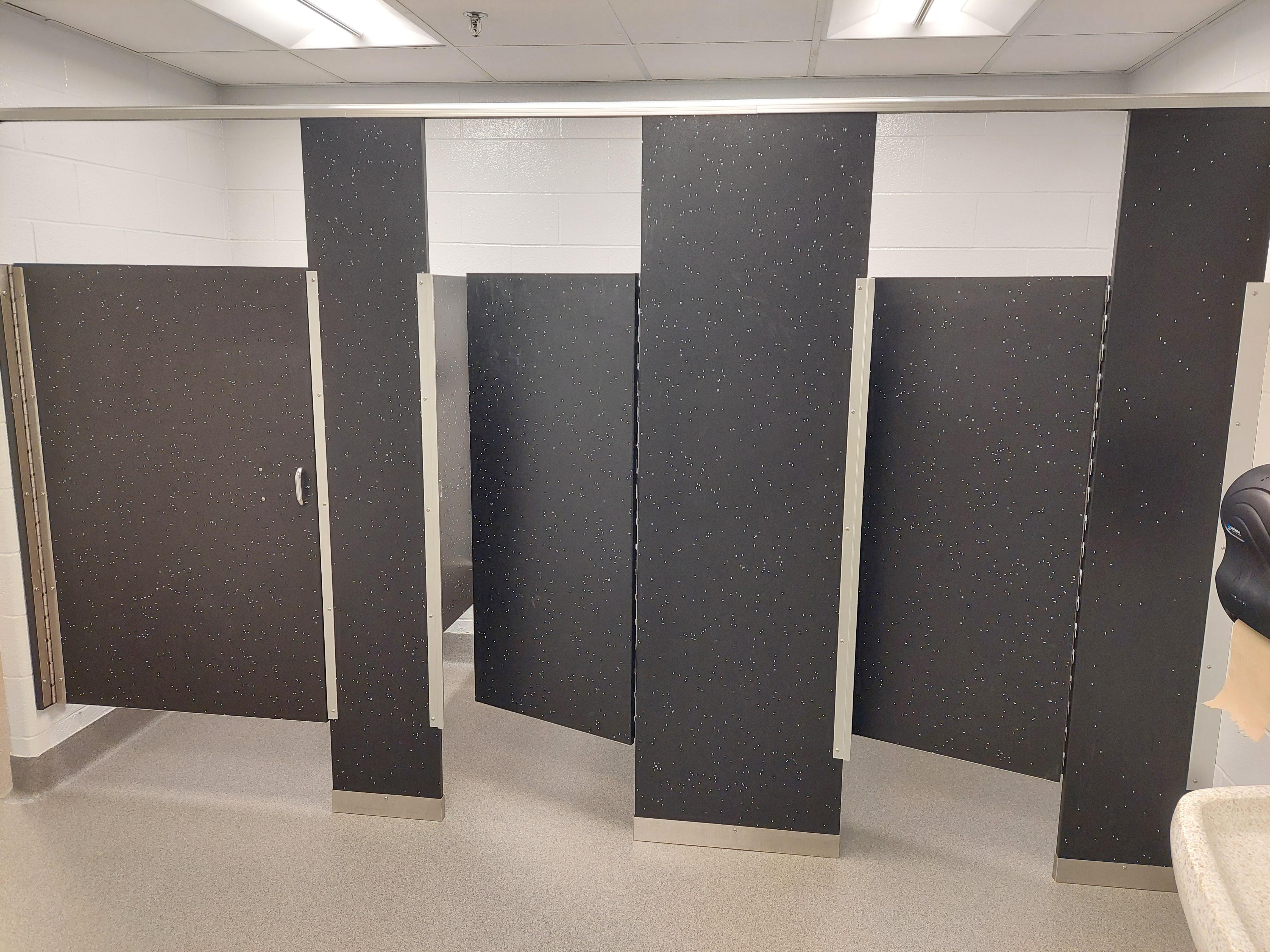 This elementary school bathroom has full stalls for the urinals r