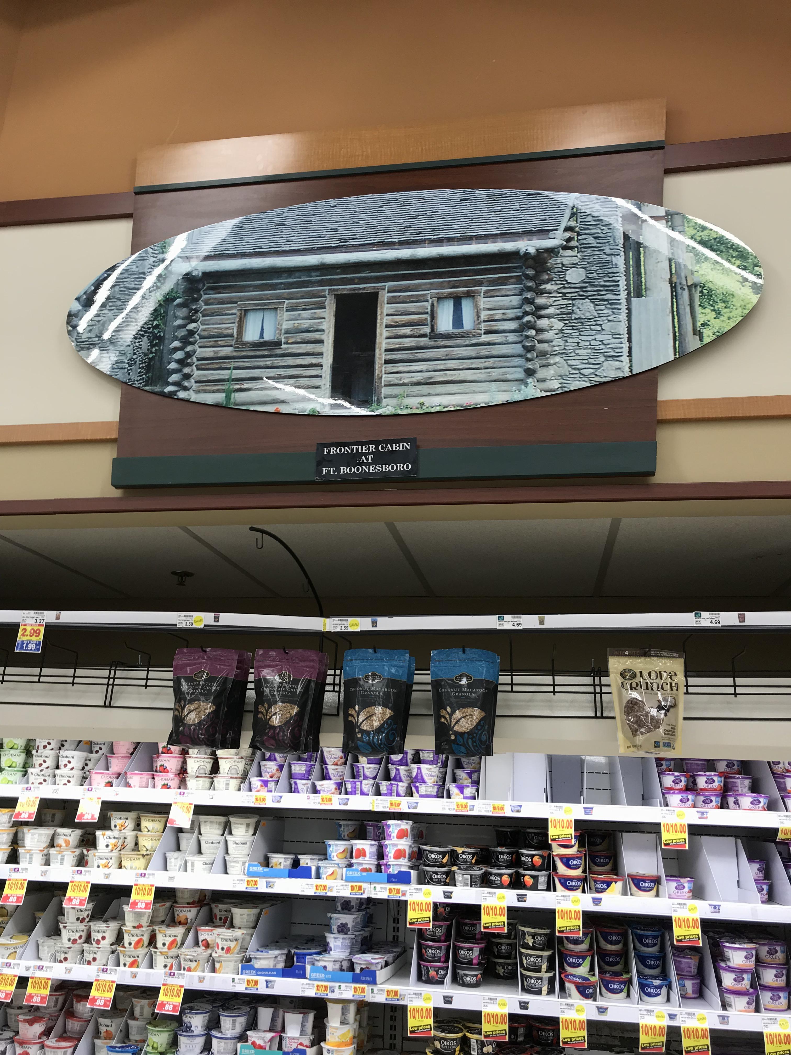 Picture of frontier fort replica hung above yogurt at supermarket