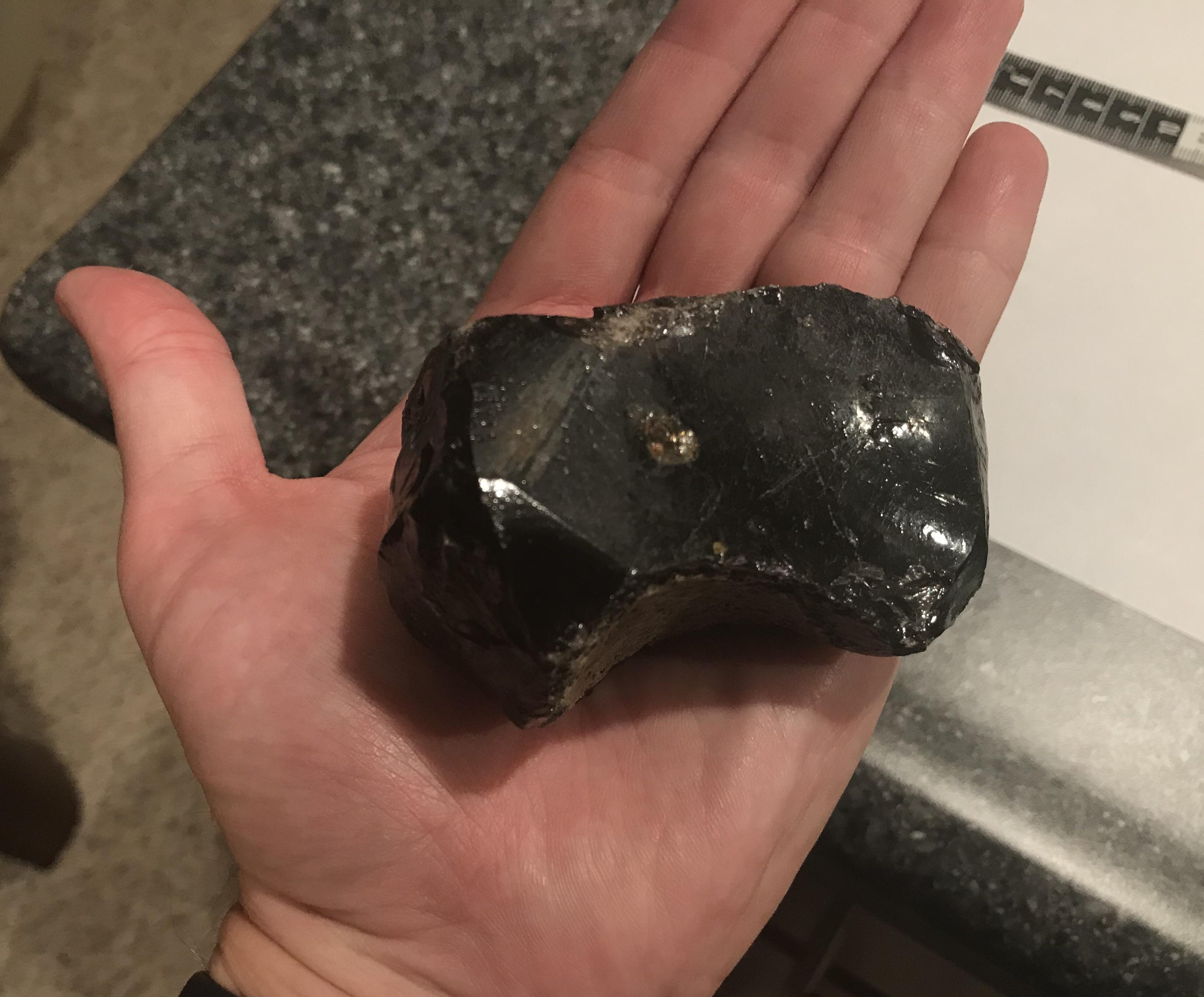About 10 cm across. Looks like obsidian and appears to have been carved