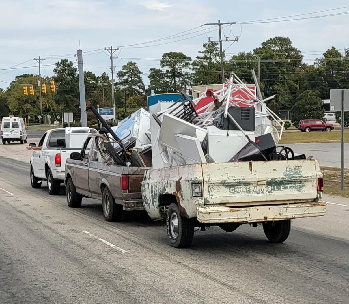 A truck towing a junk truck towing a junk truck bed trailer
