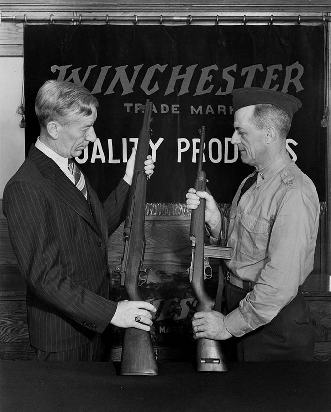 E.E. Scherer (superintendent of Winchester firearms production) holding
