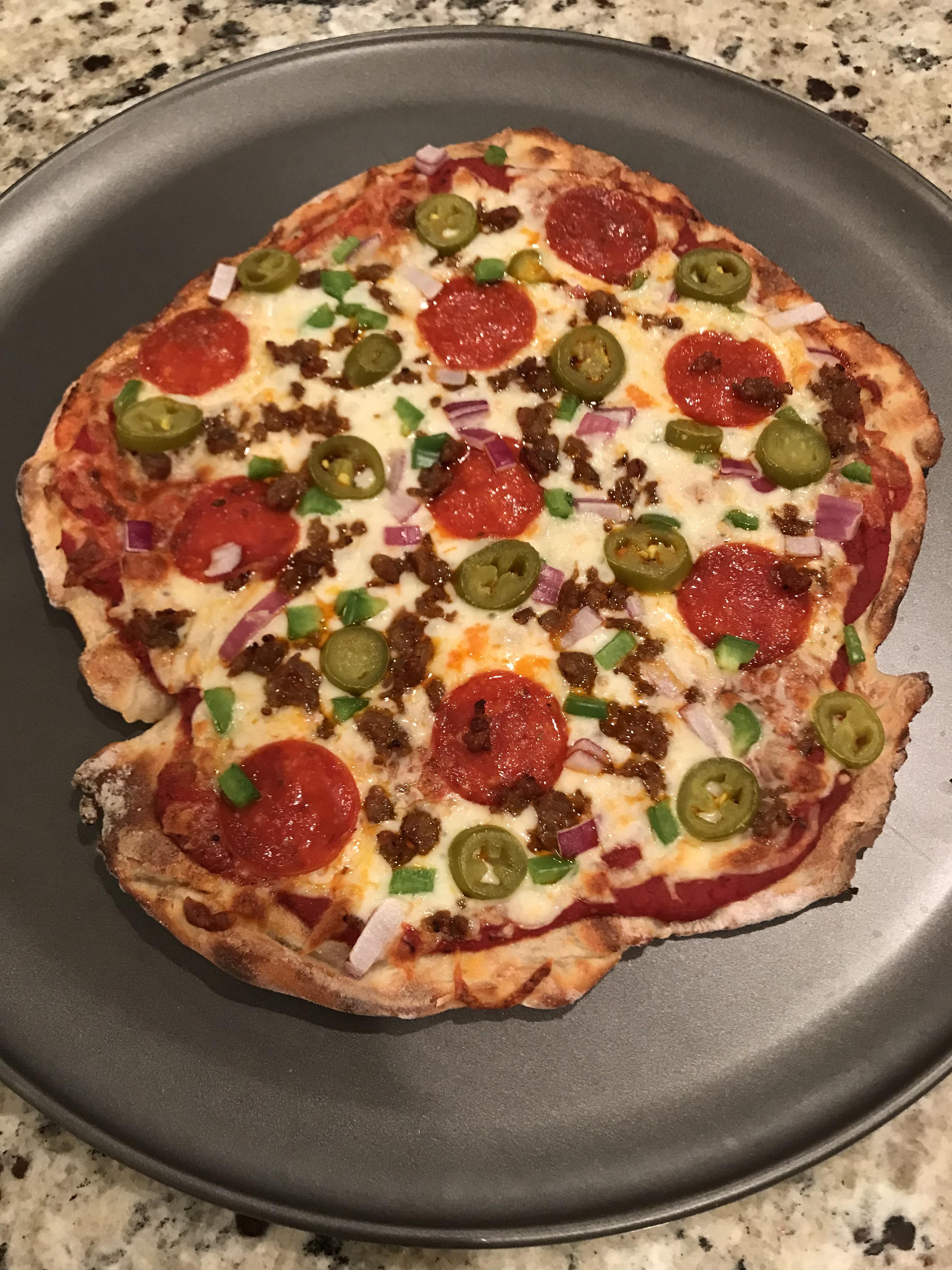 Homemade pizza with hot Italian sausage, pepperoni, onion, bell pepper
