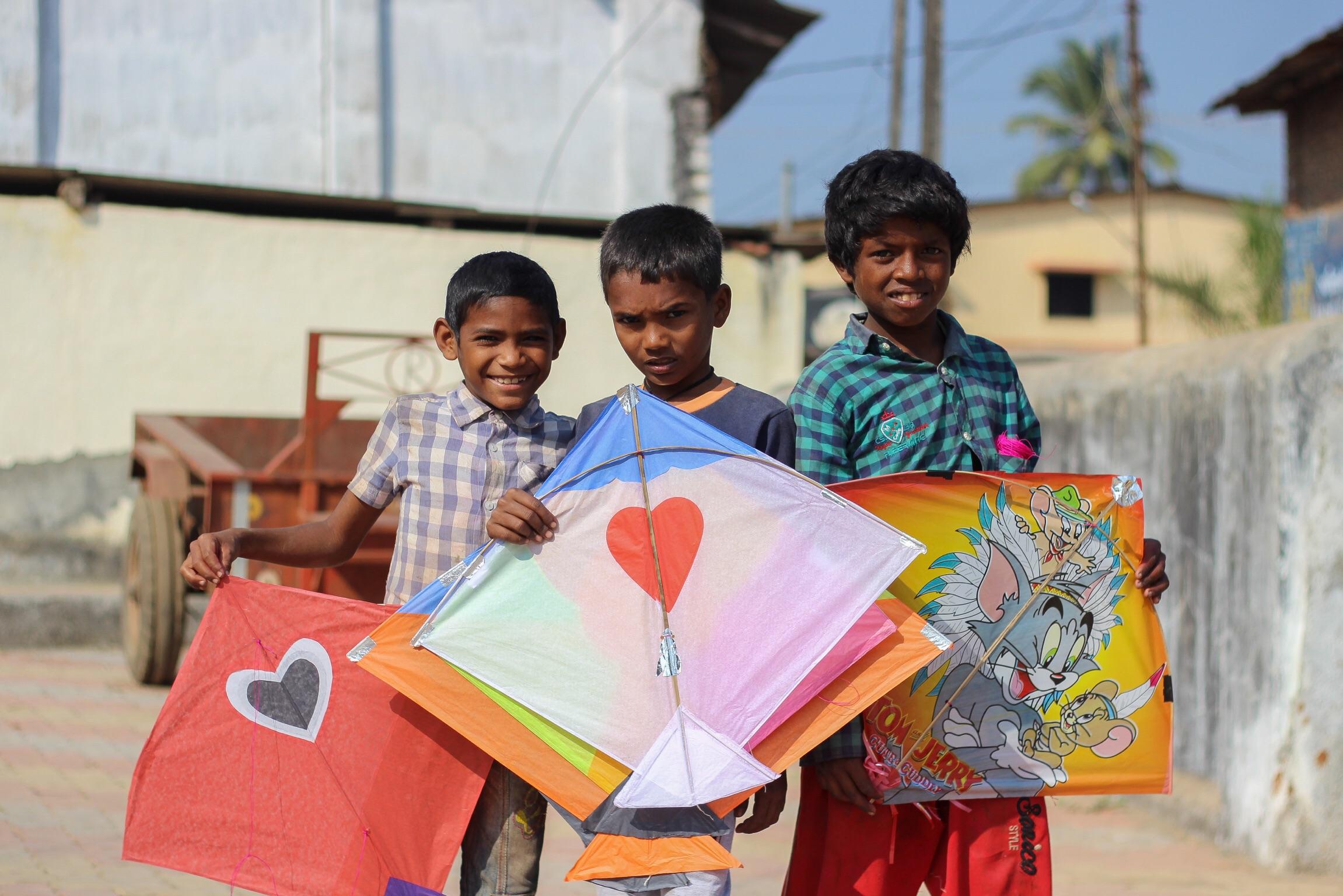 Kids showing off the kites they managed to pick up that had fallen