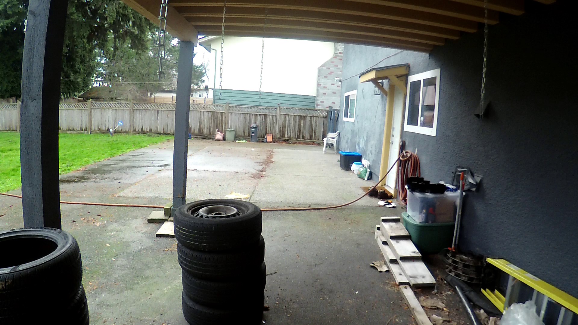 How to enclose this carport on uneven asphalt? wood frame between