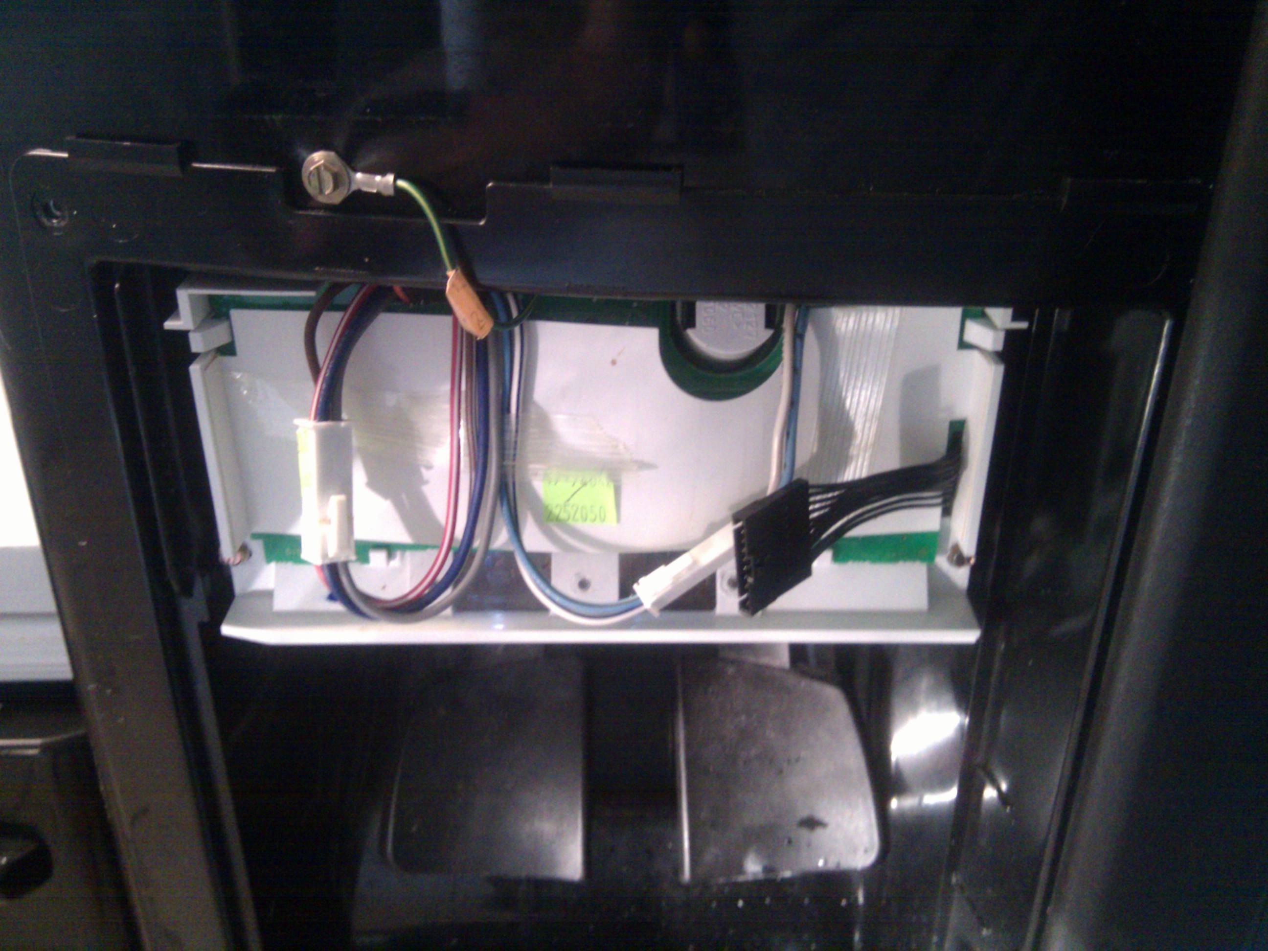 How do I remove the front panel of my refrigerator to replace the water