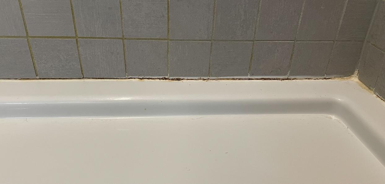 caulking Shower stall base bows downward from body weight, causing