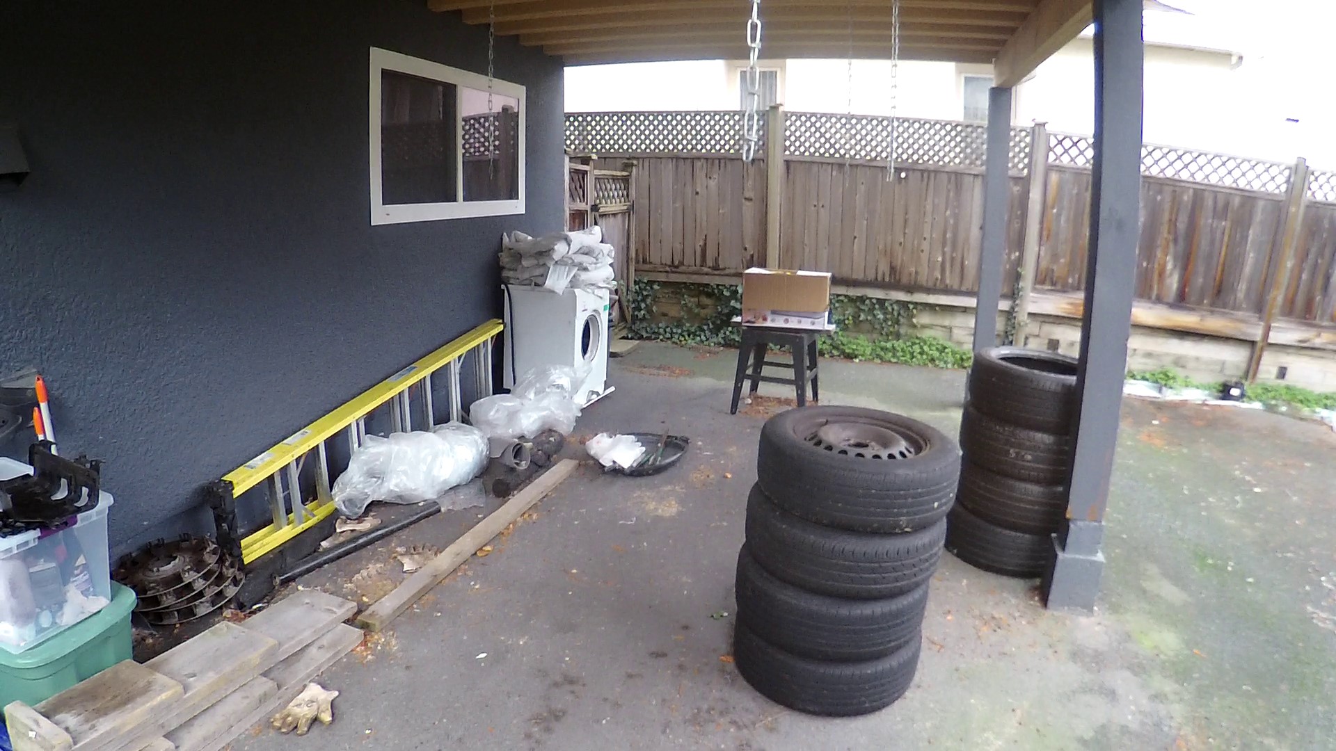 How to enclose this carport on uneven asphalt? wood frame between