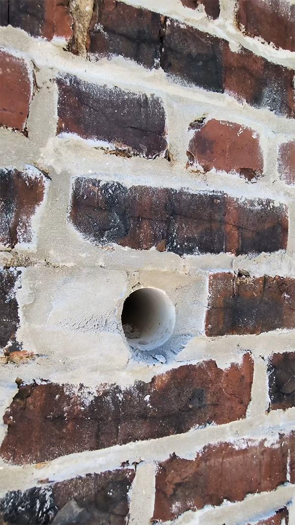exterior What is this pipe that is uncovered outside of my brick wall