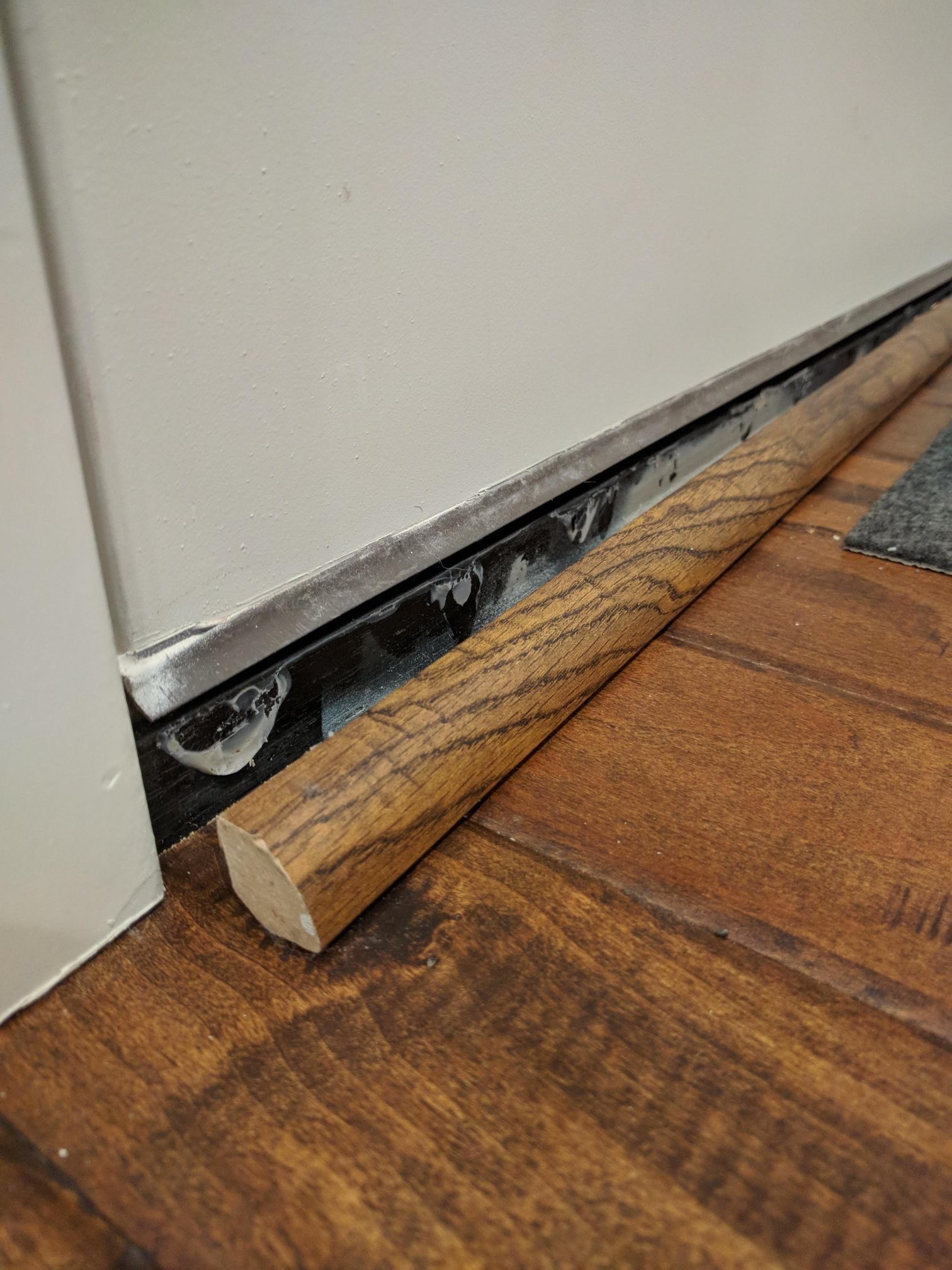 repair Reattach quarterround molding under front door Home