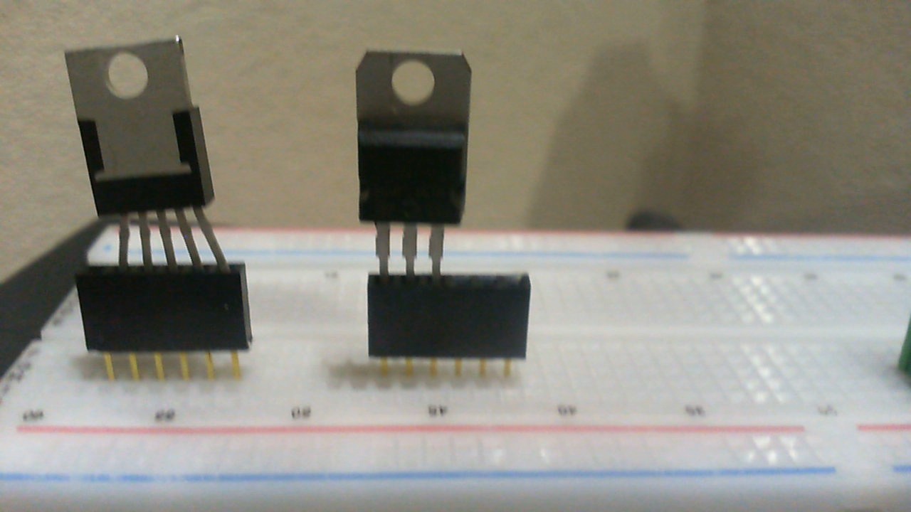 The process of positioning a 7805 voltage regulator on a breadboard