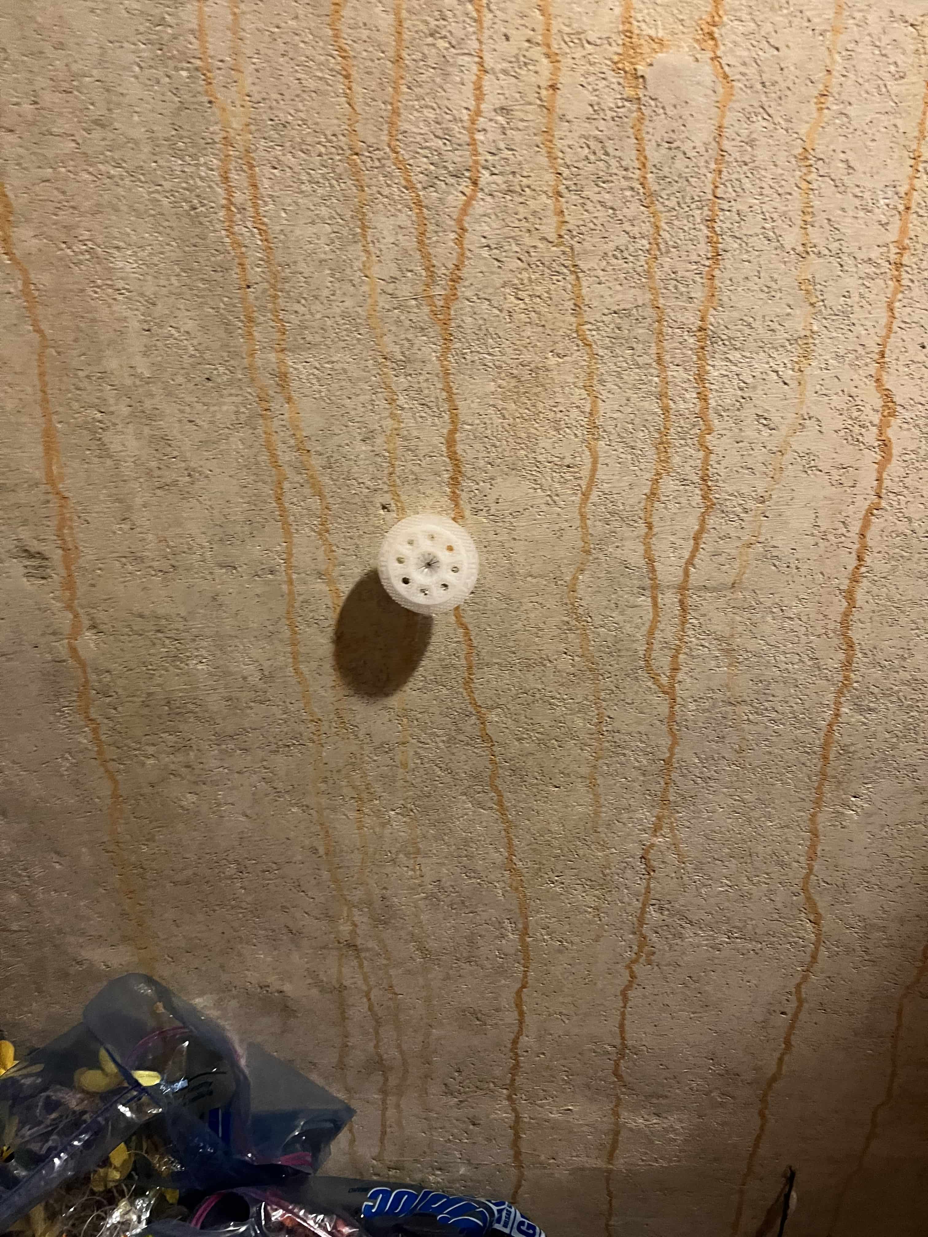 Red and orange streaks leaking down my concrete basement wall, and is