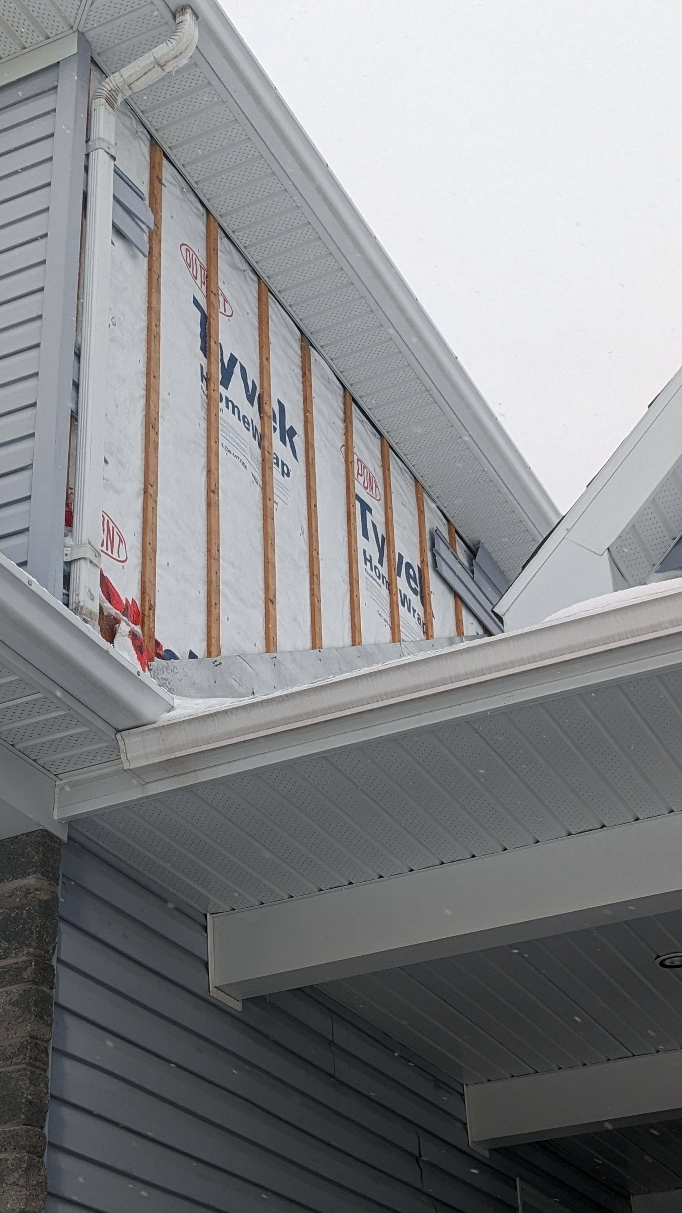 exterior Home siding blown off by strong wind. Wood and housewrap