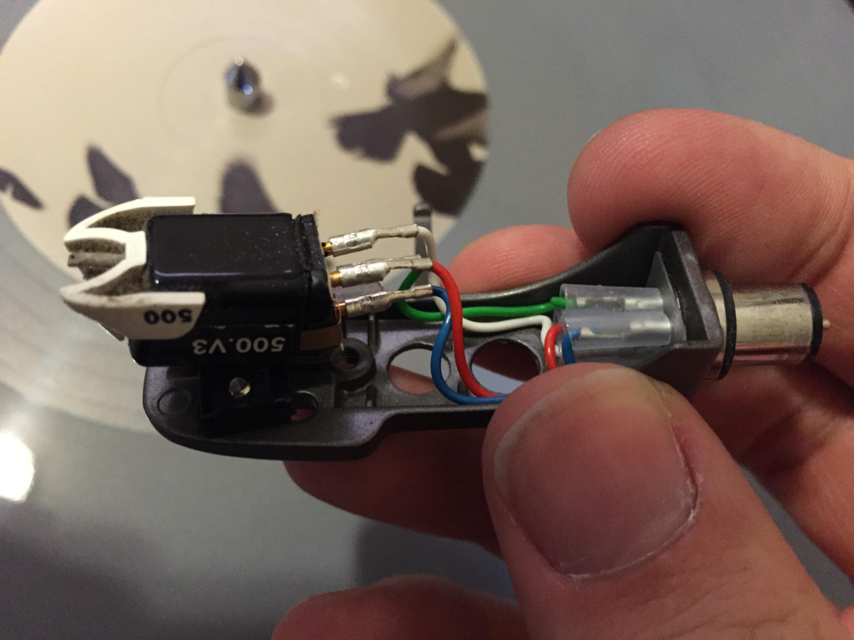 electromagnetism - Why do I hear voices when I touch my turntable