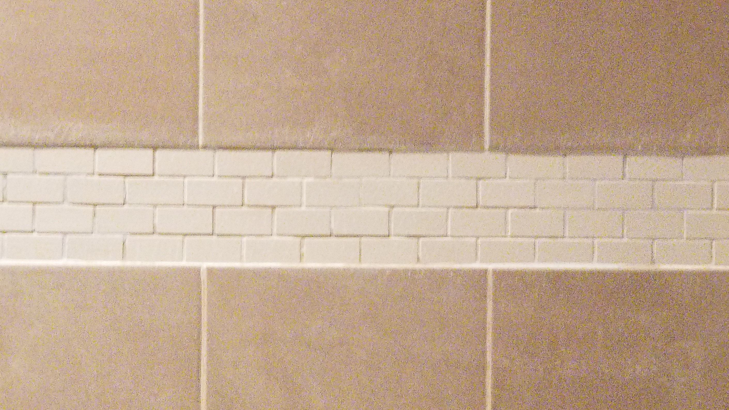 Can I tile over a horizontal band of tiles in my shower? Home