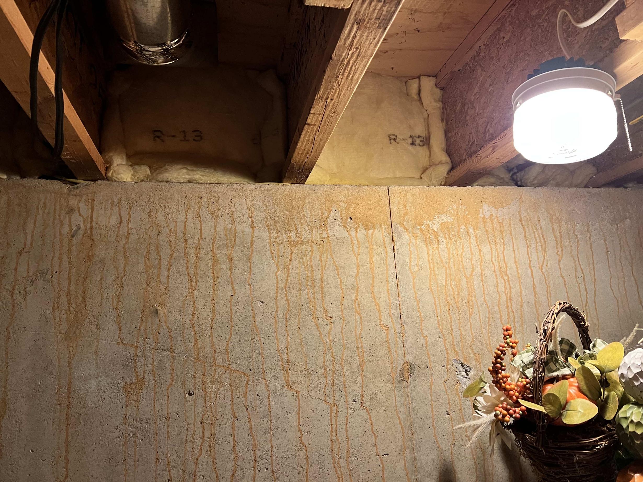 Red and orange streaks leaking down my concrete basement wall, and is