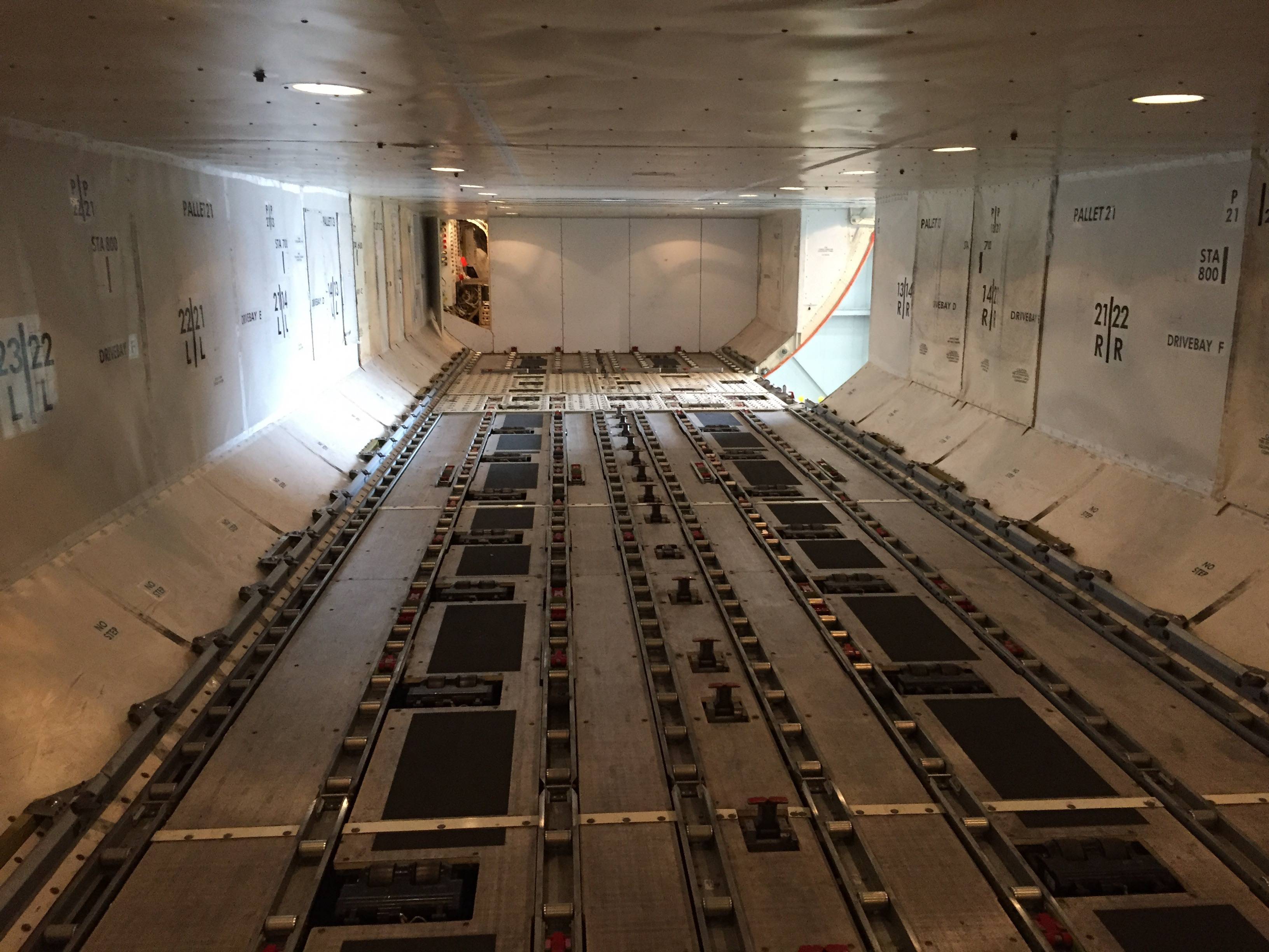 Why is the shape of the cargo compartment similar in large aircraft