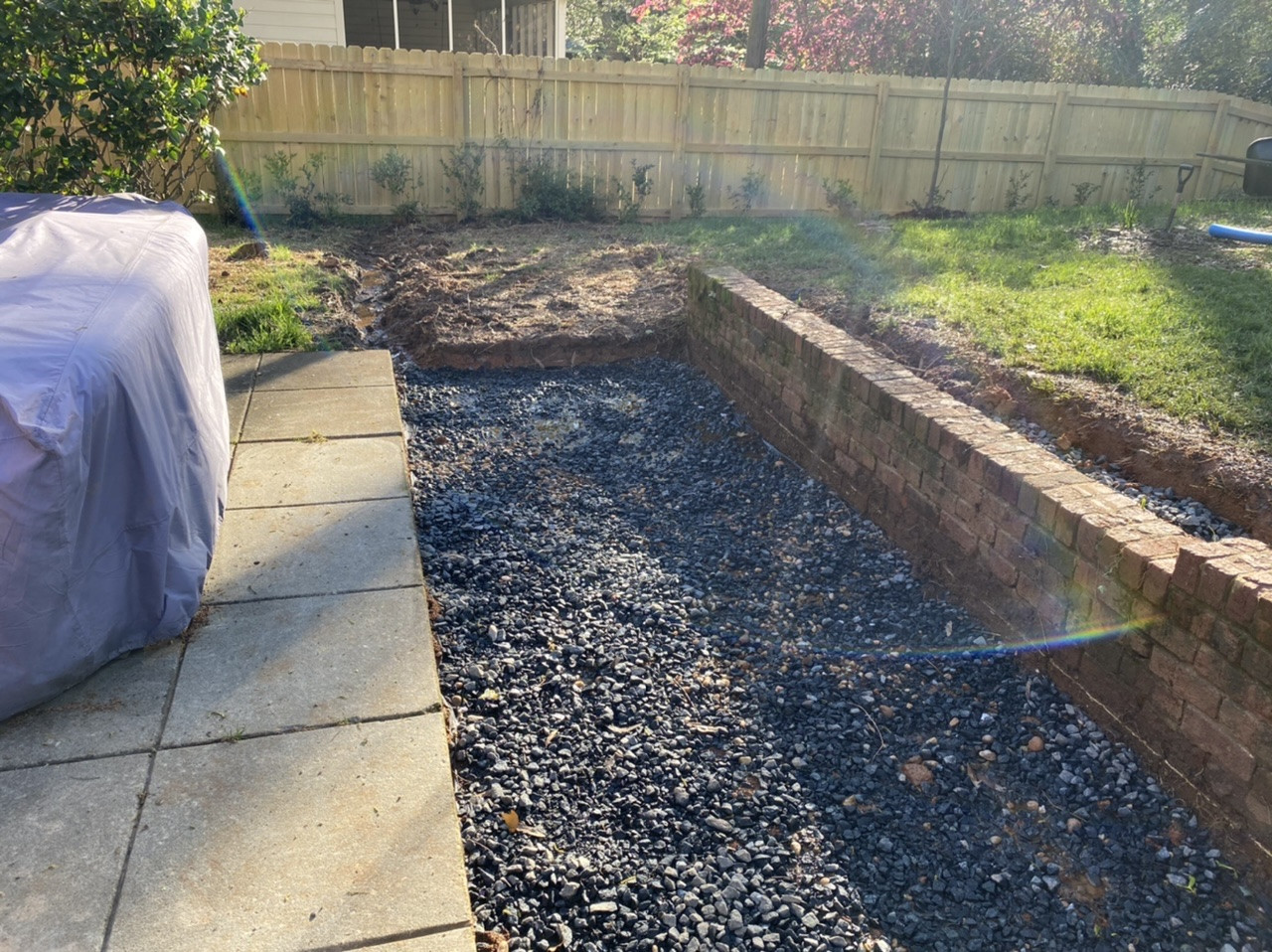 Concrete How should I drain an area of gravel between a sidewalk and