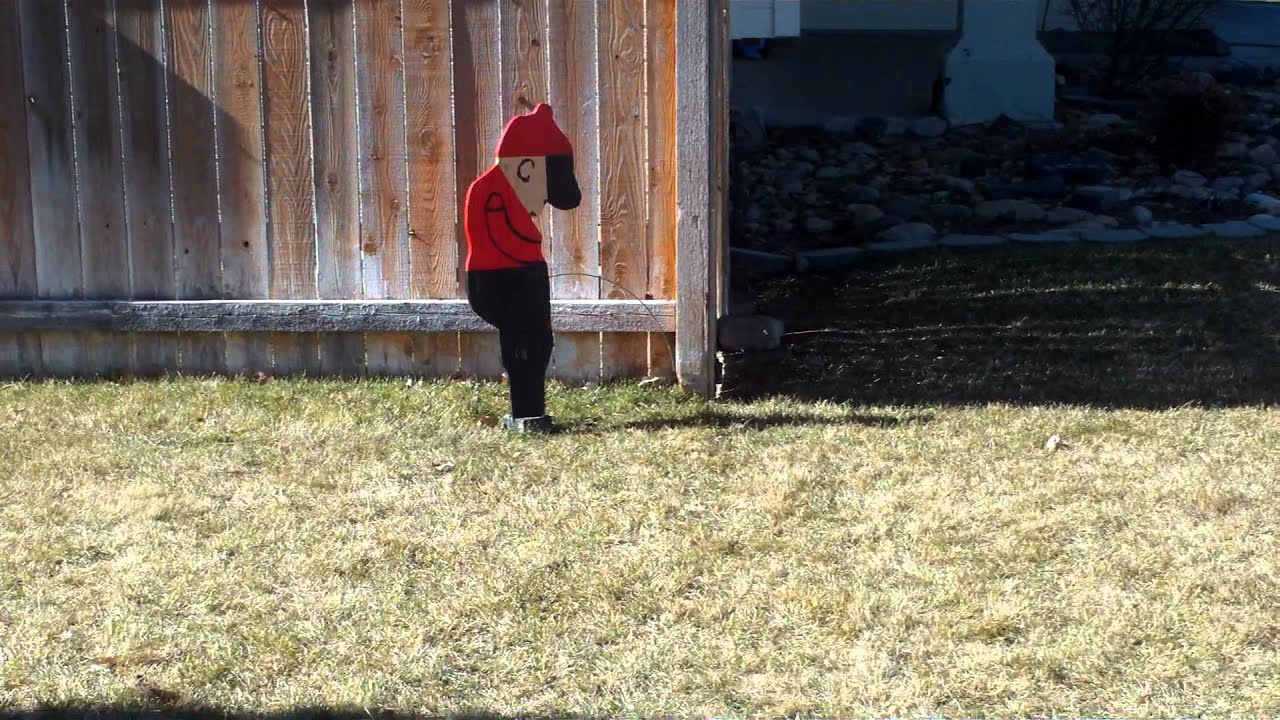 a board in a yard dipicting a boy peeing on a fence YouTube