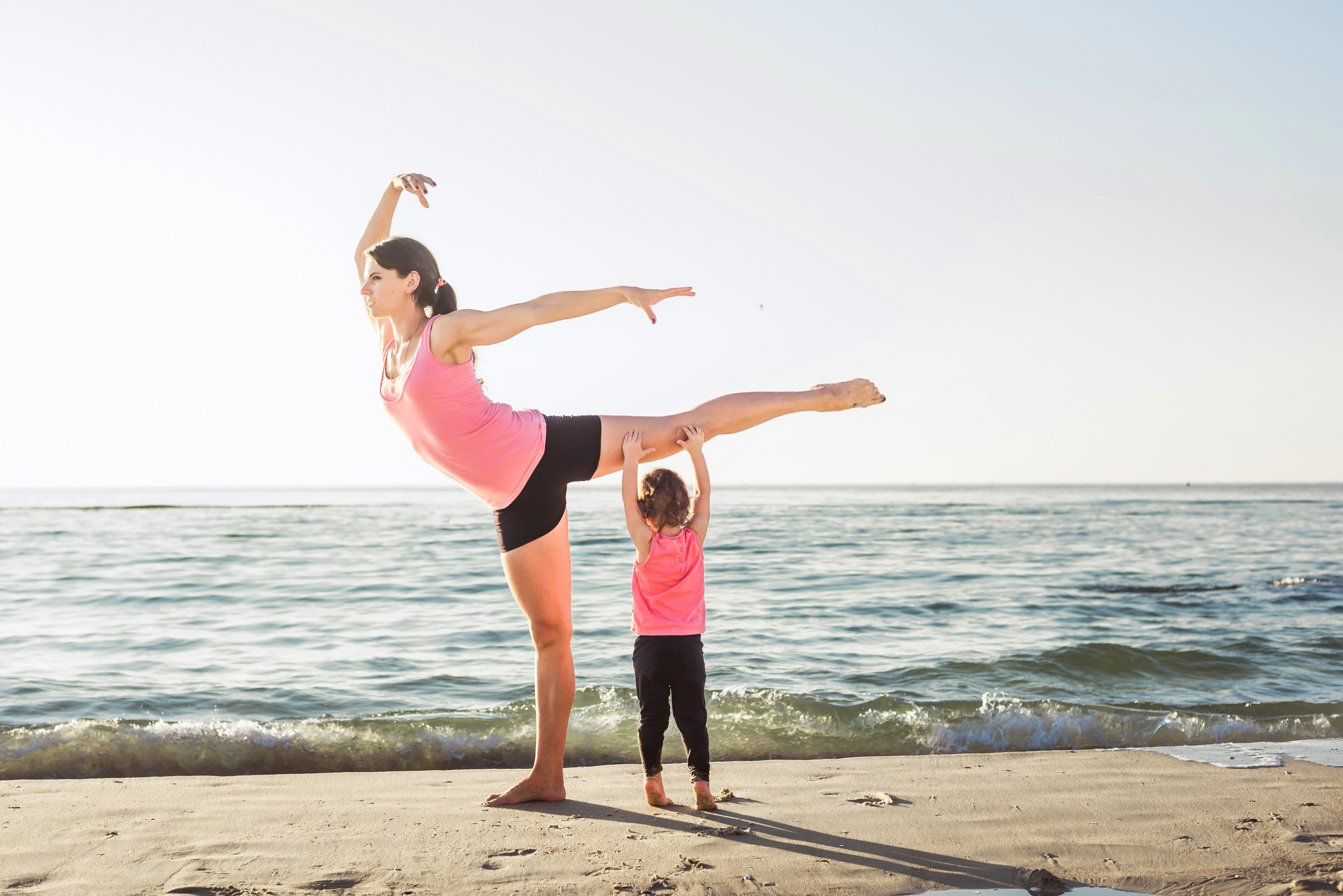 family workout mother and daughter doing exercises on beach. H ICmed