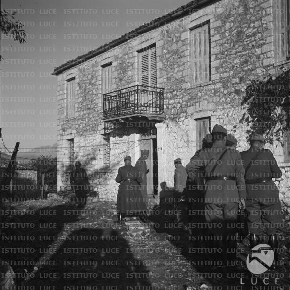 Soldati e ufficiali italiani stazionano nelle vicinanze di un edificio
