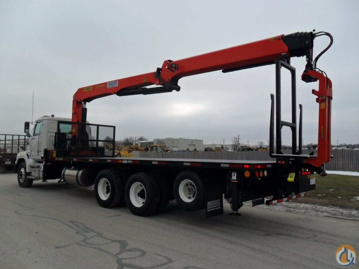 Crane spills its entire load of pipes from the top story of a building
