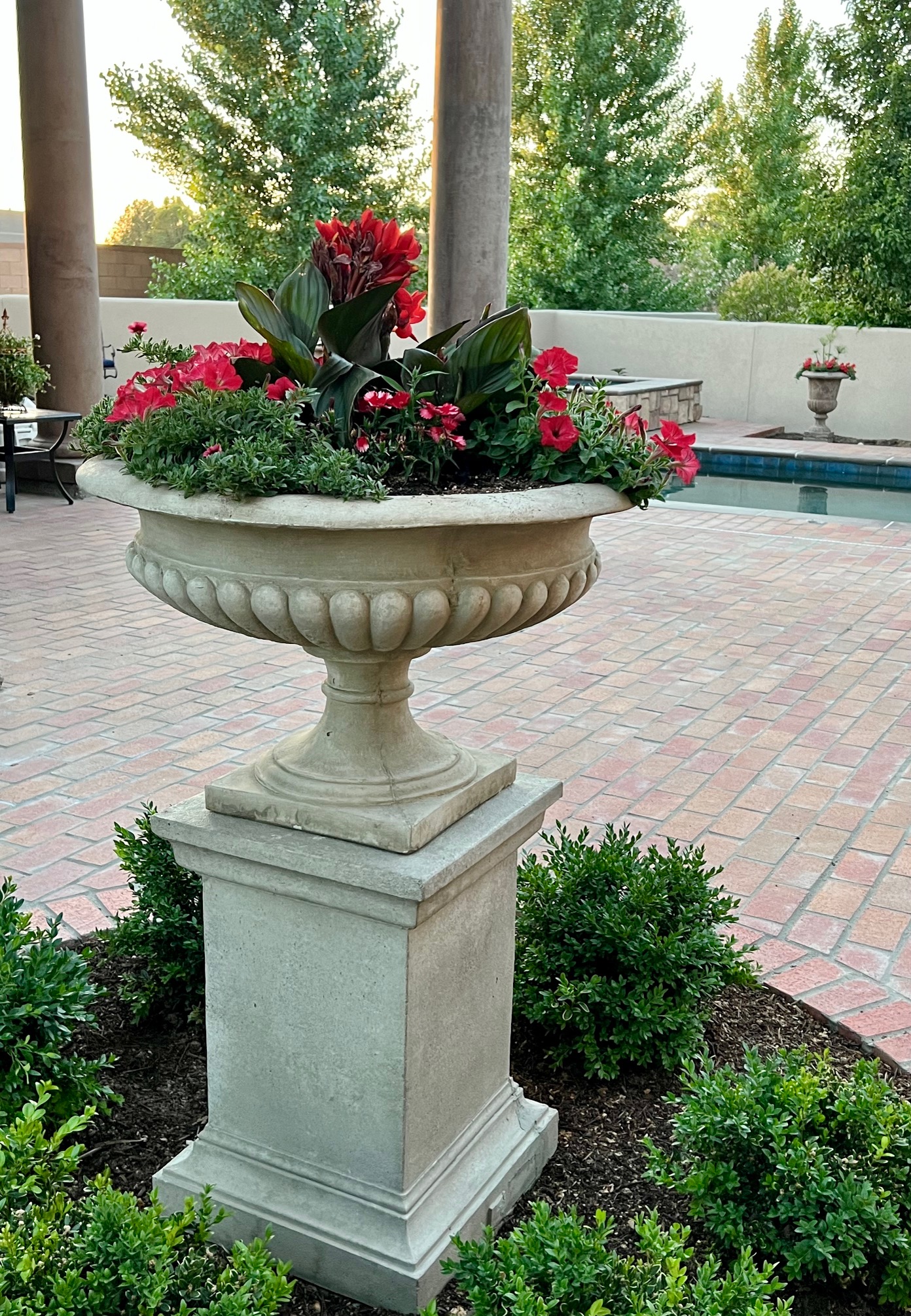 stone urn container with red flowers