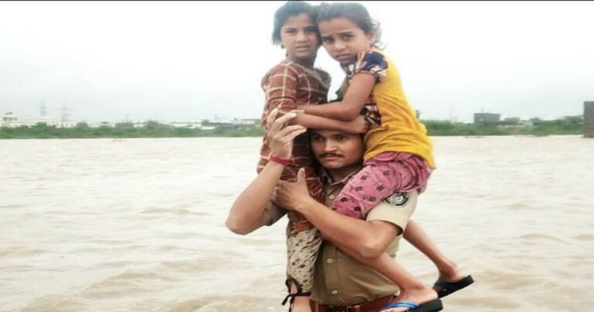 Gujarat constable carries two children on shoulders in waistdeep flood