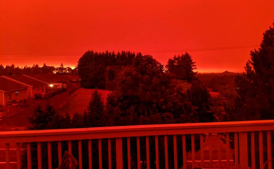 California skies glow orange as firefighters battle wildfires that rage