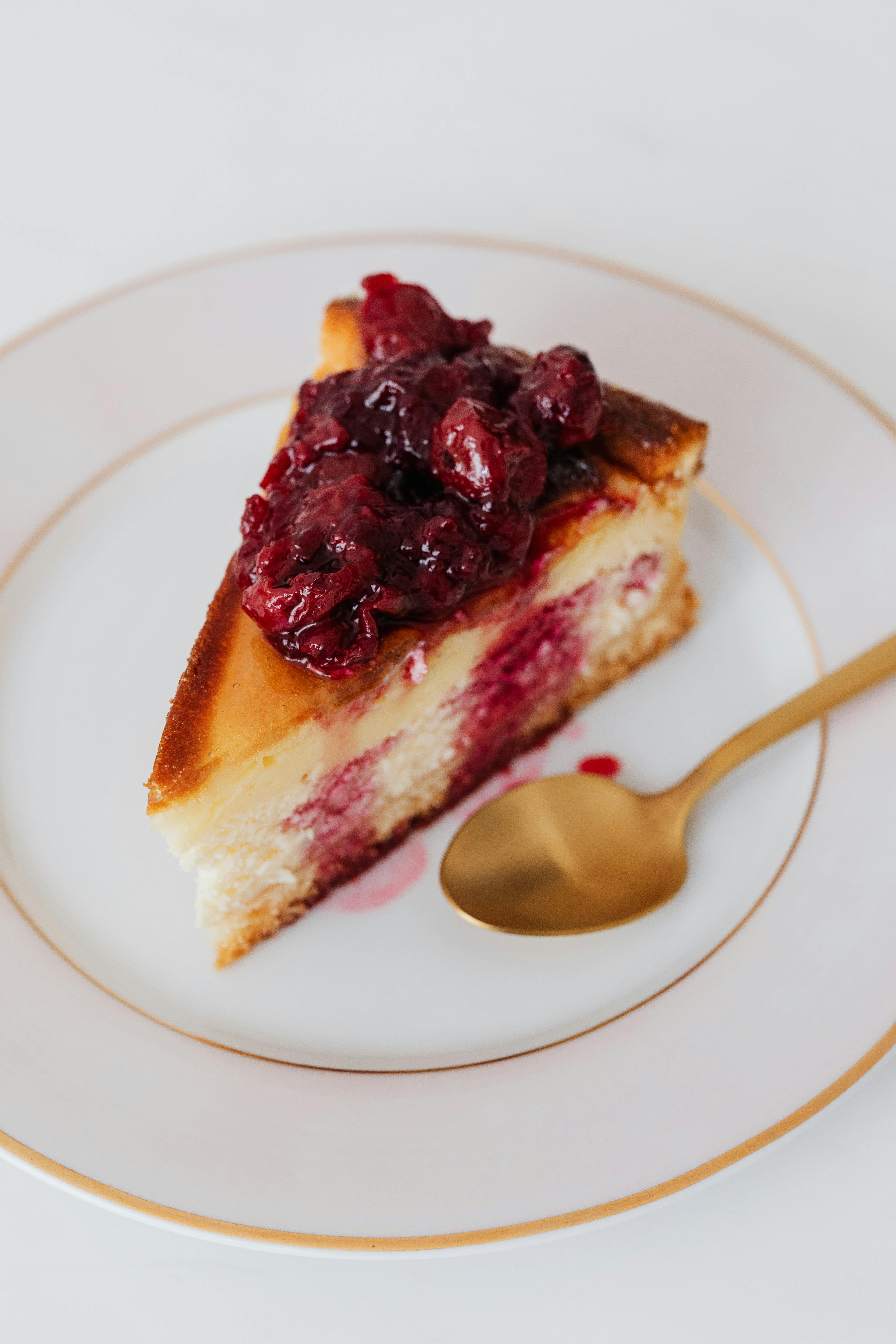 Piece of cheesecake garnished with cherries in syrup · Free Stock Photo