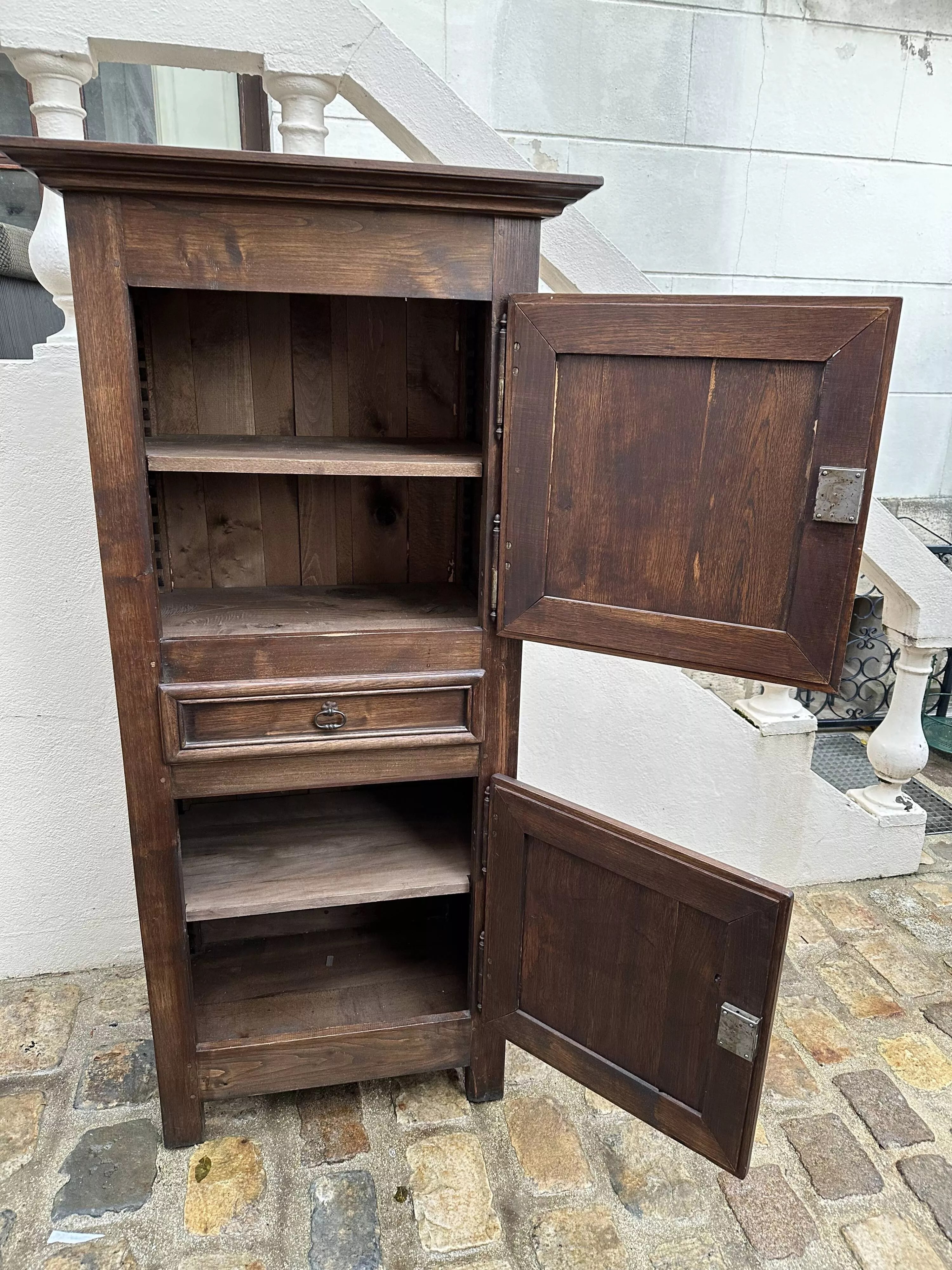Homme debout armoire étroite à deux portes avec un tiroir central