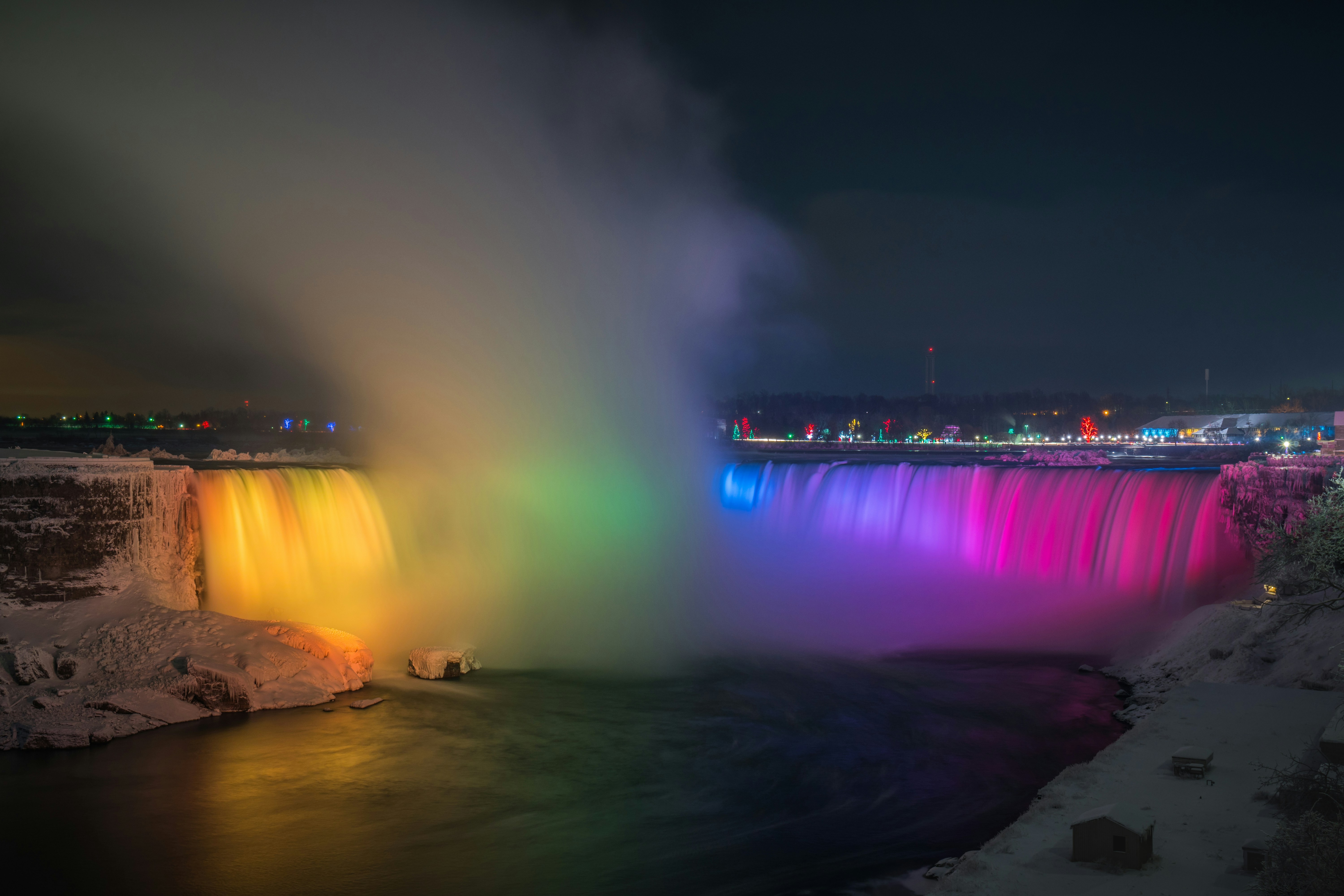 Niagara Falls with lights and overlooking view of buildings during