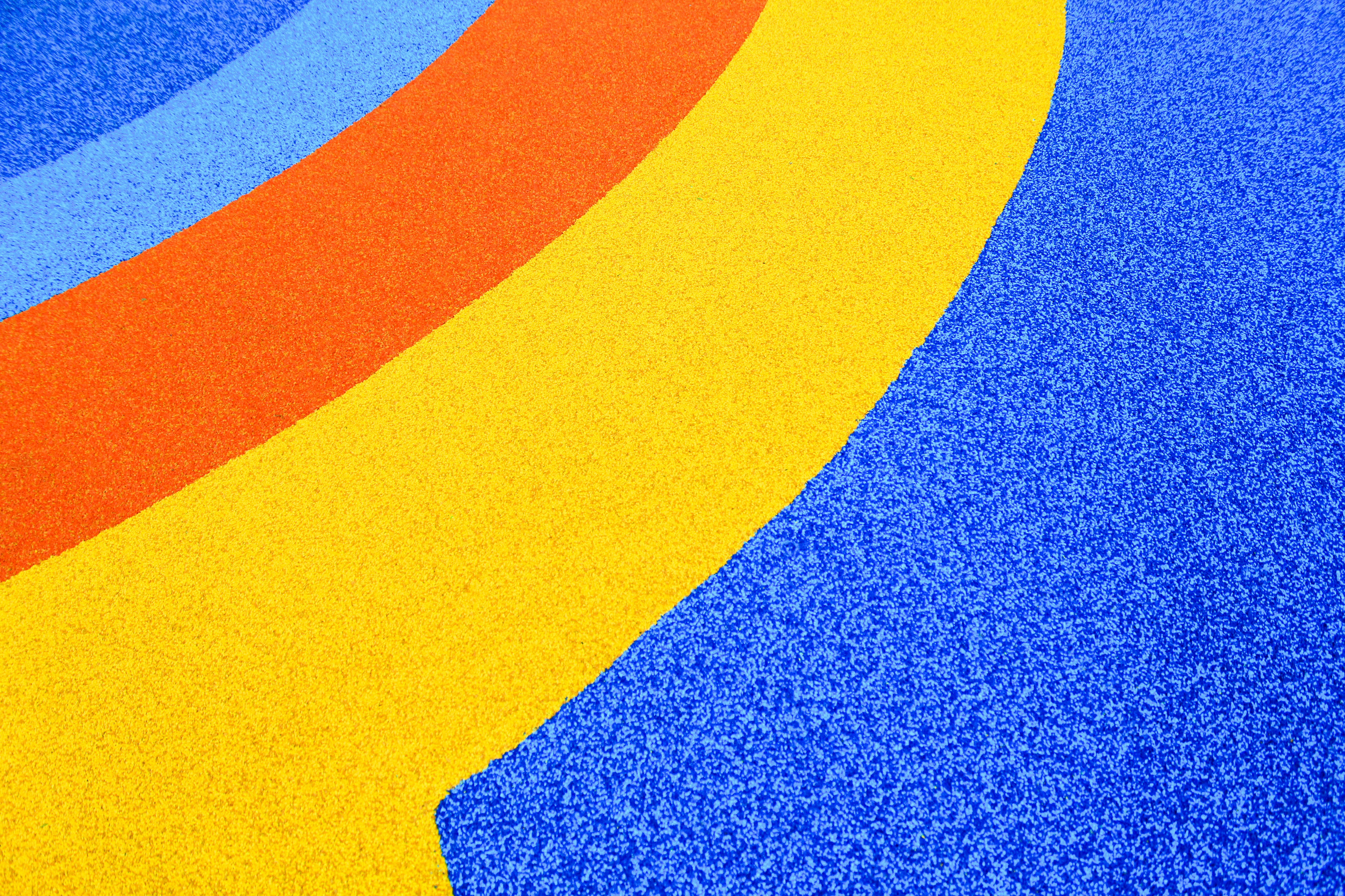 A blue, yellow, and red carpet with a curved design photo Free Yellow