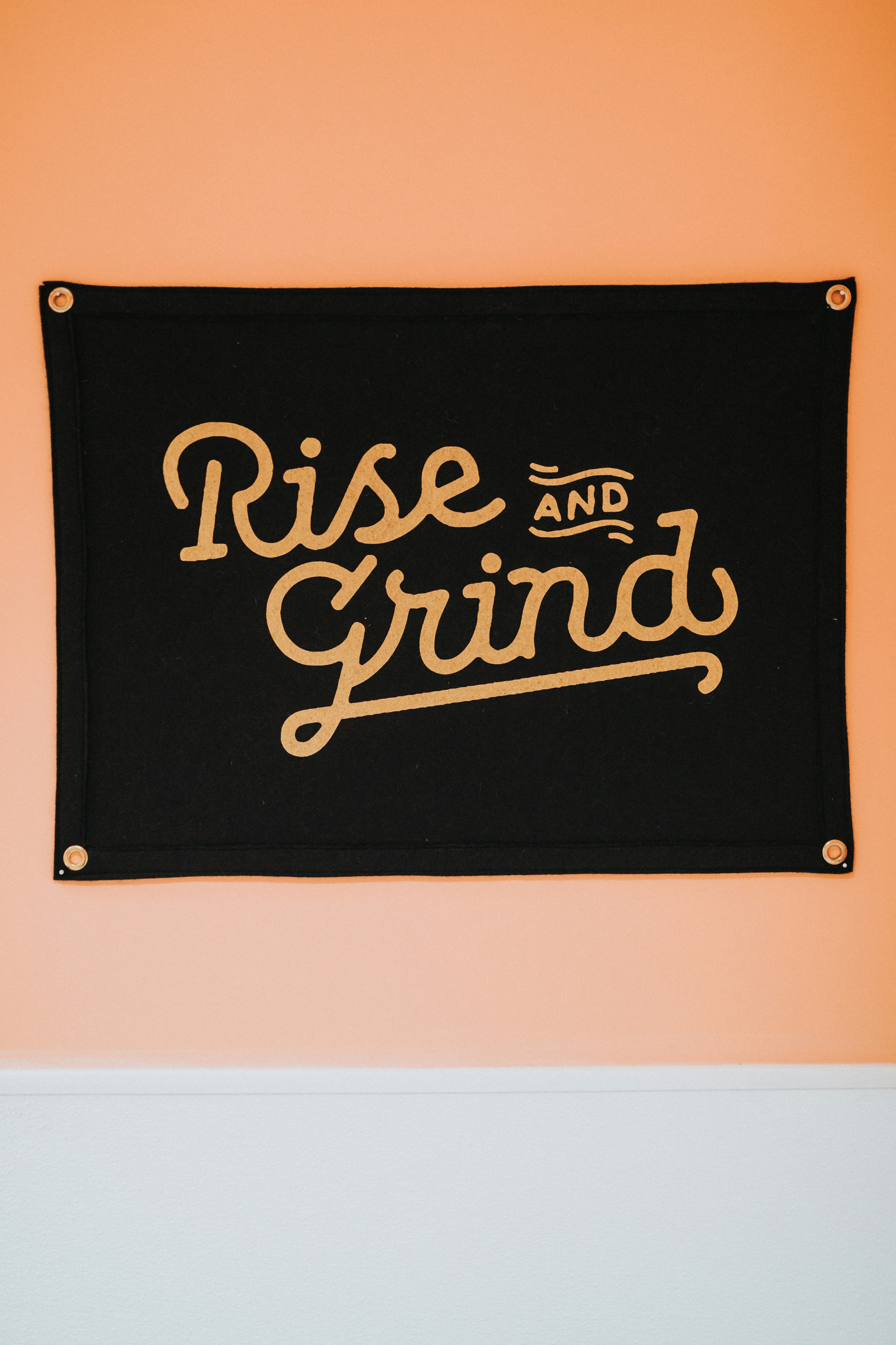 Black rise and grind wall decor mounted on brown wall photo Free Text