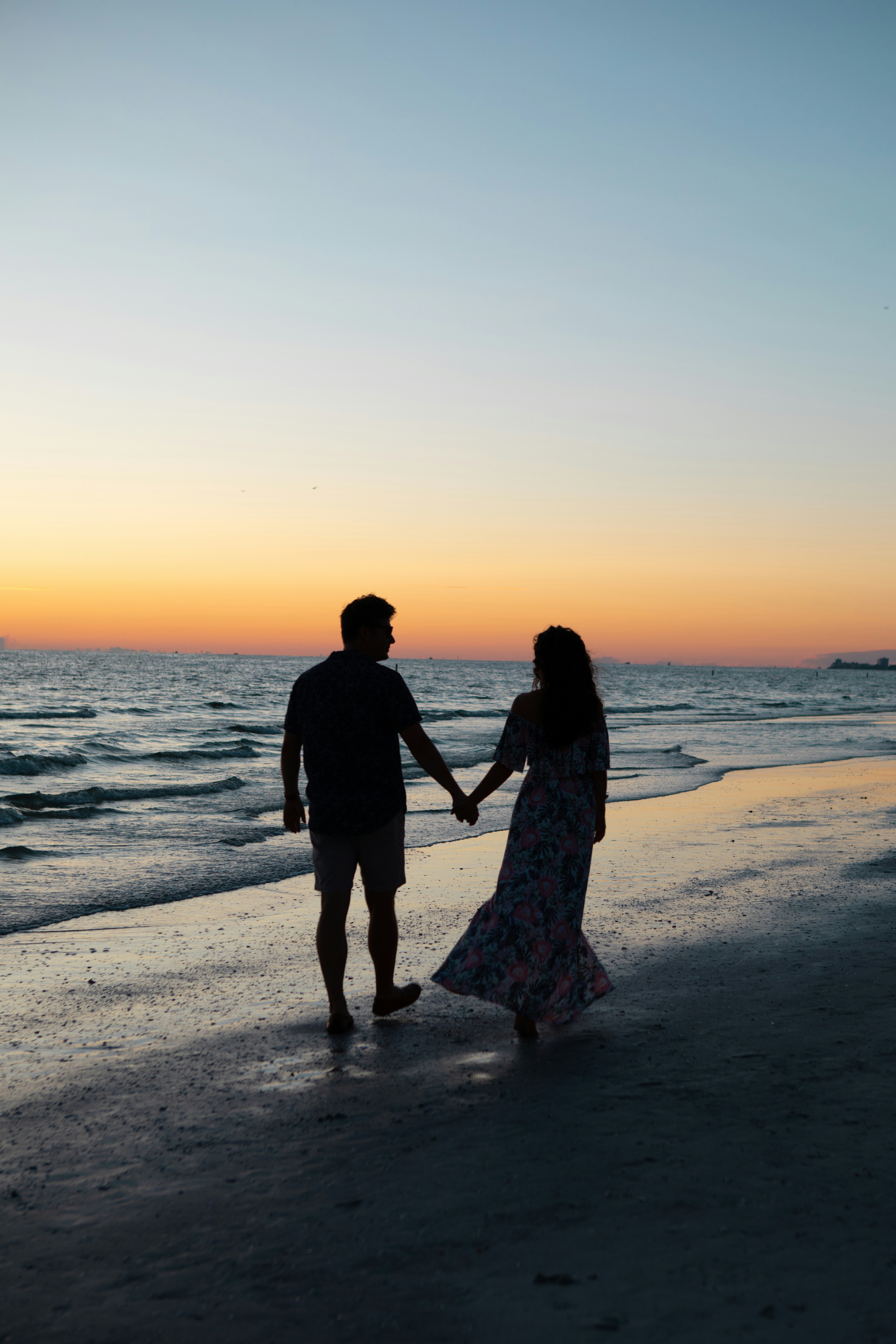 photography of man and woman holding hands each other while walking