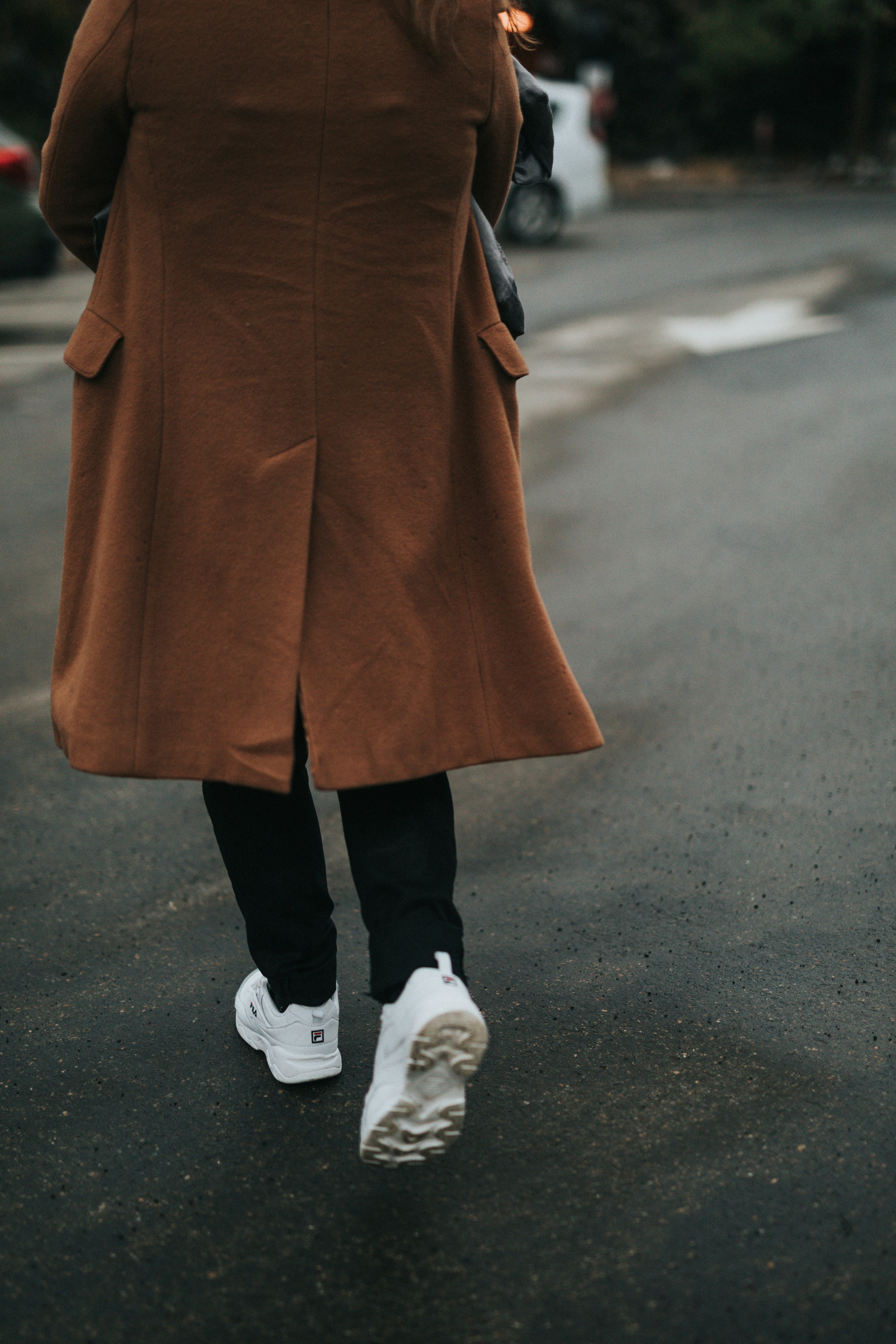 Person wearing brown coat, black, pants, and white shoes photo Free