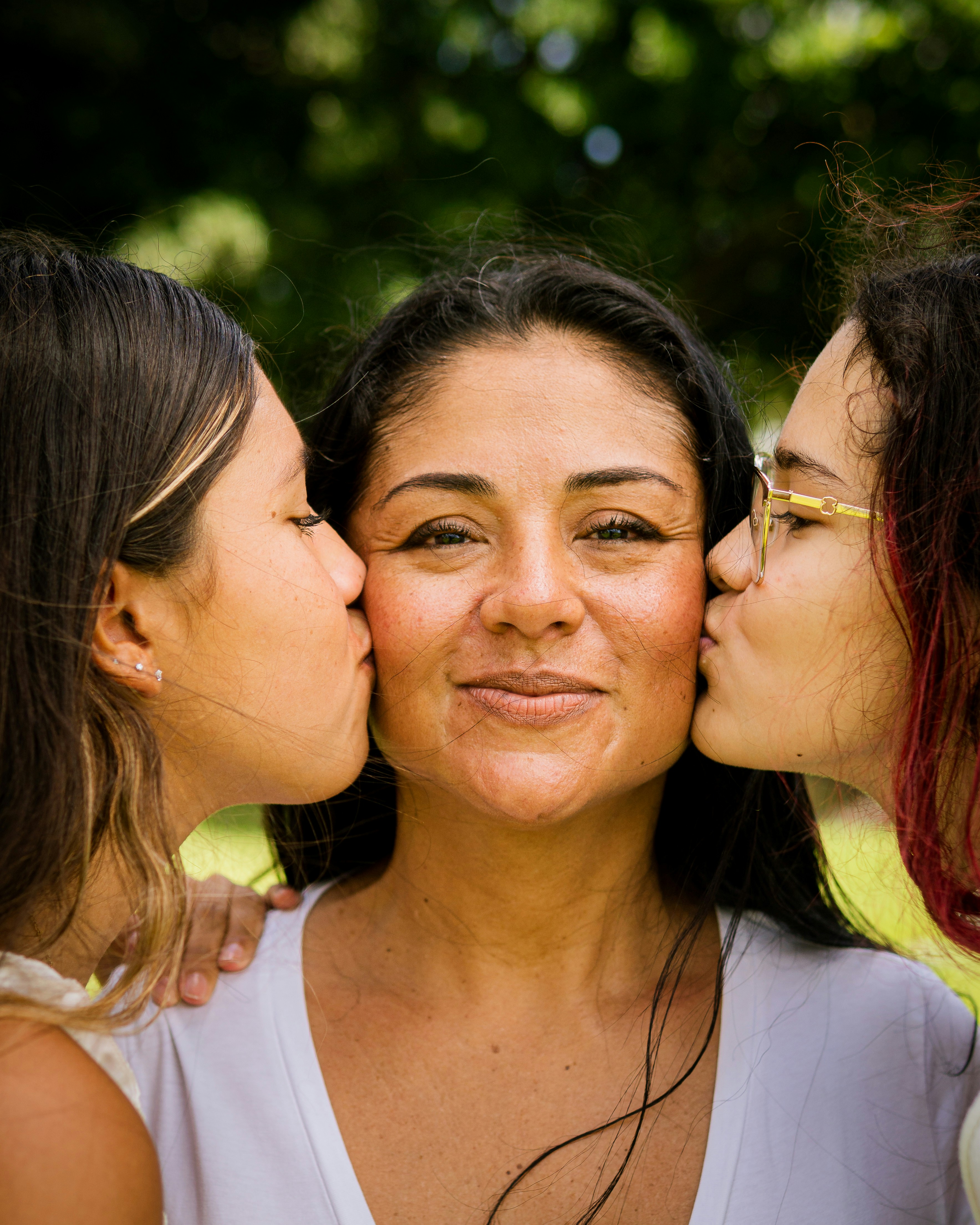 Three women kissing each other with their noses close together photo