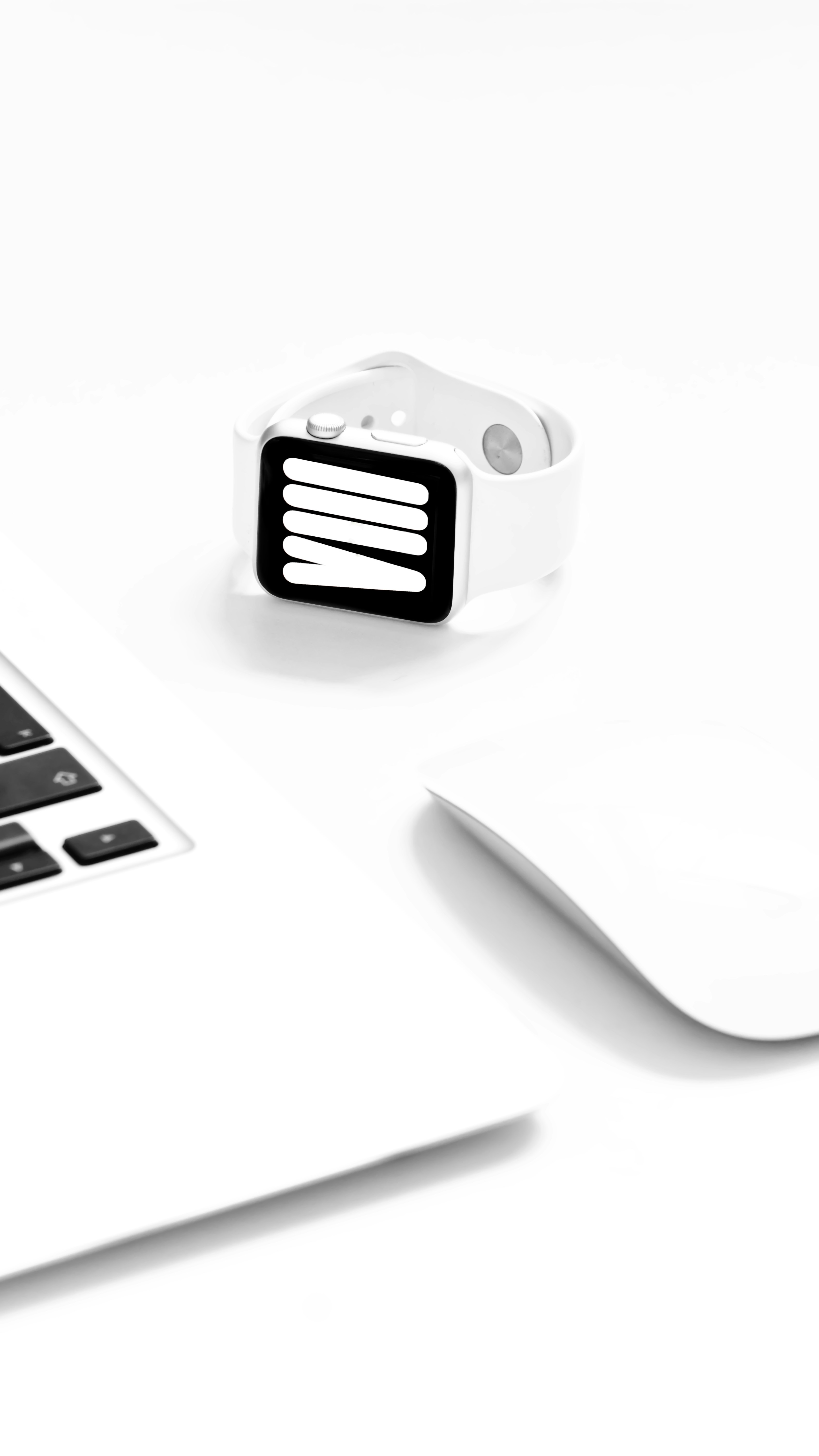 A white apple watch sitting on top of a laptop computer photo Free