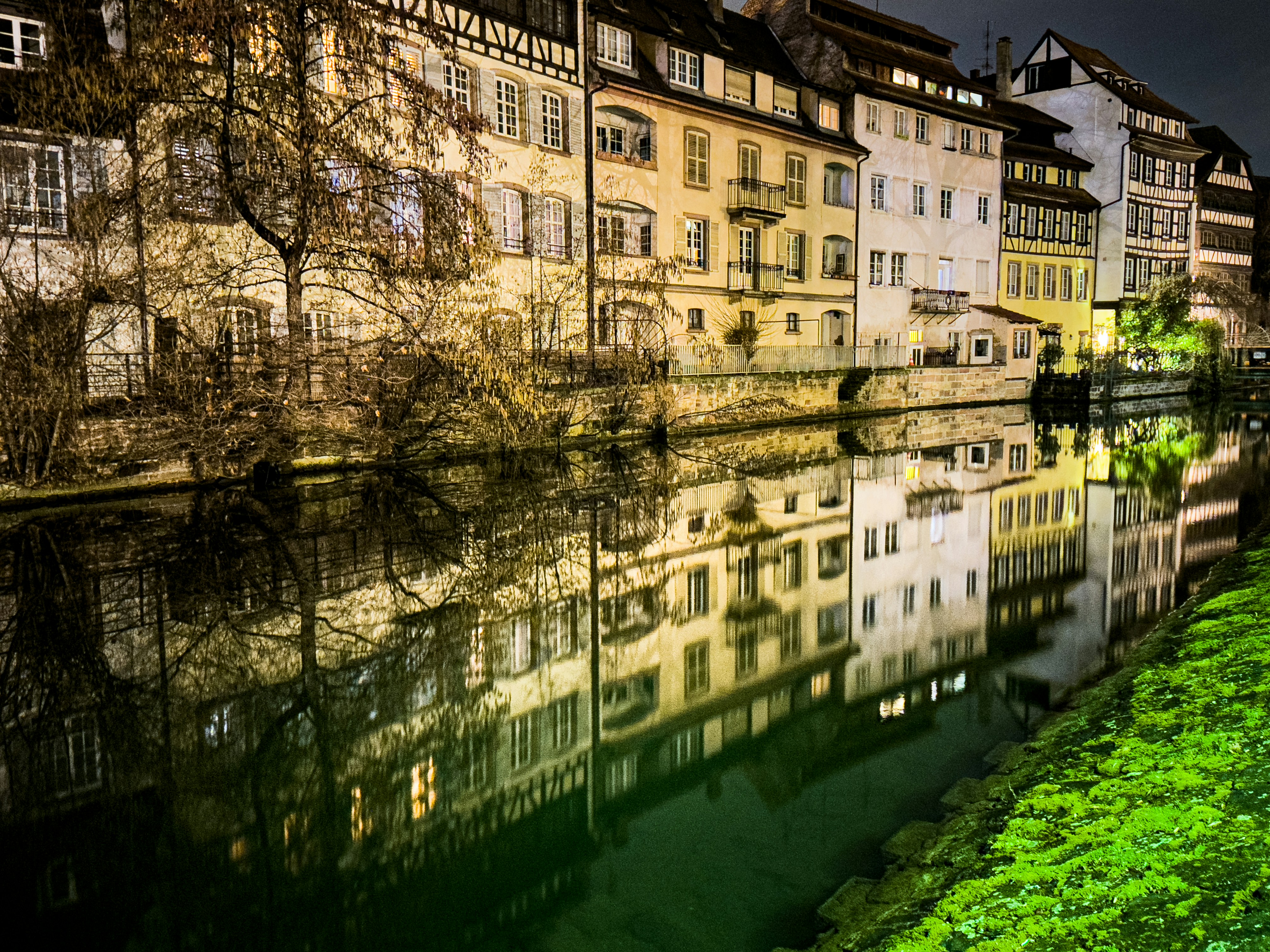 Une rivière qui traverse une ville à côté de grands immeubles photo